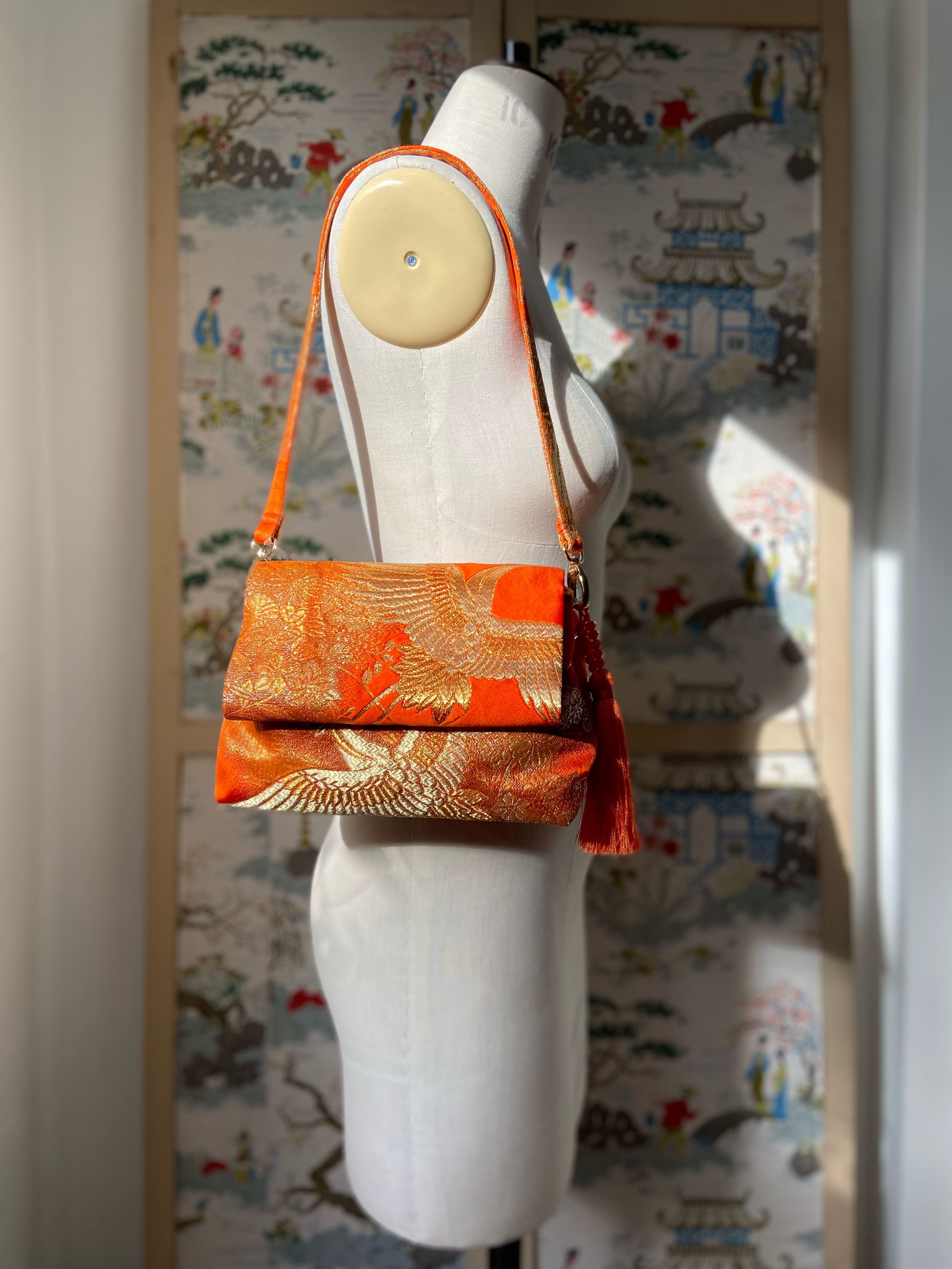 Vibrant orange evening bag with gold copper crane and blossom design, handmade from vintage obi silk by Kirsty Chivers