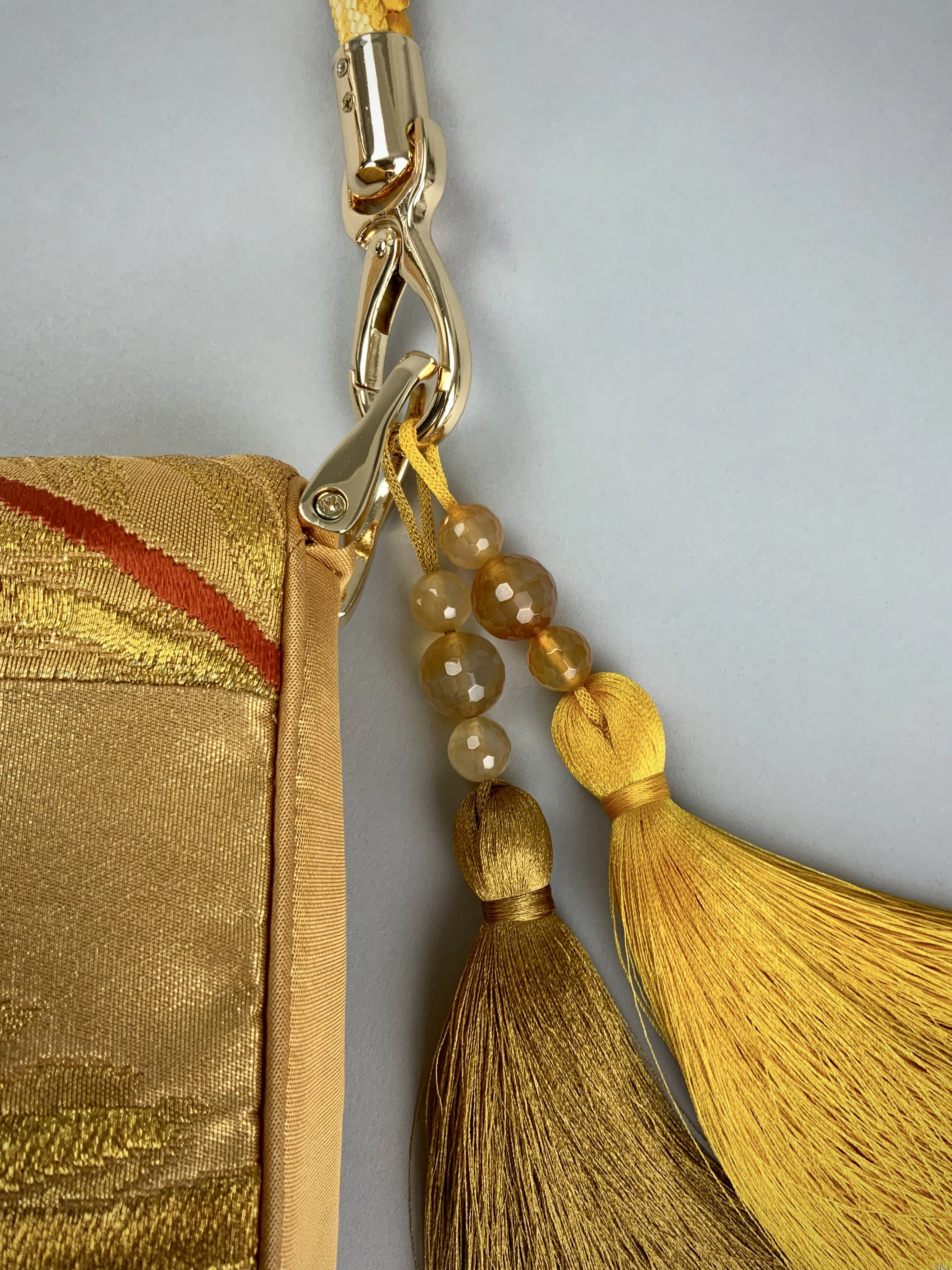 Closeup of luminous metallic gold baguette evening bag made from vintage Japanese obi silk by Kirsty Chivers