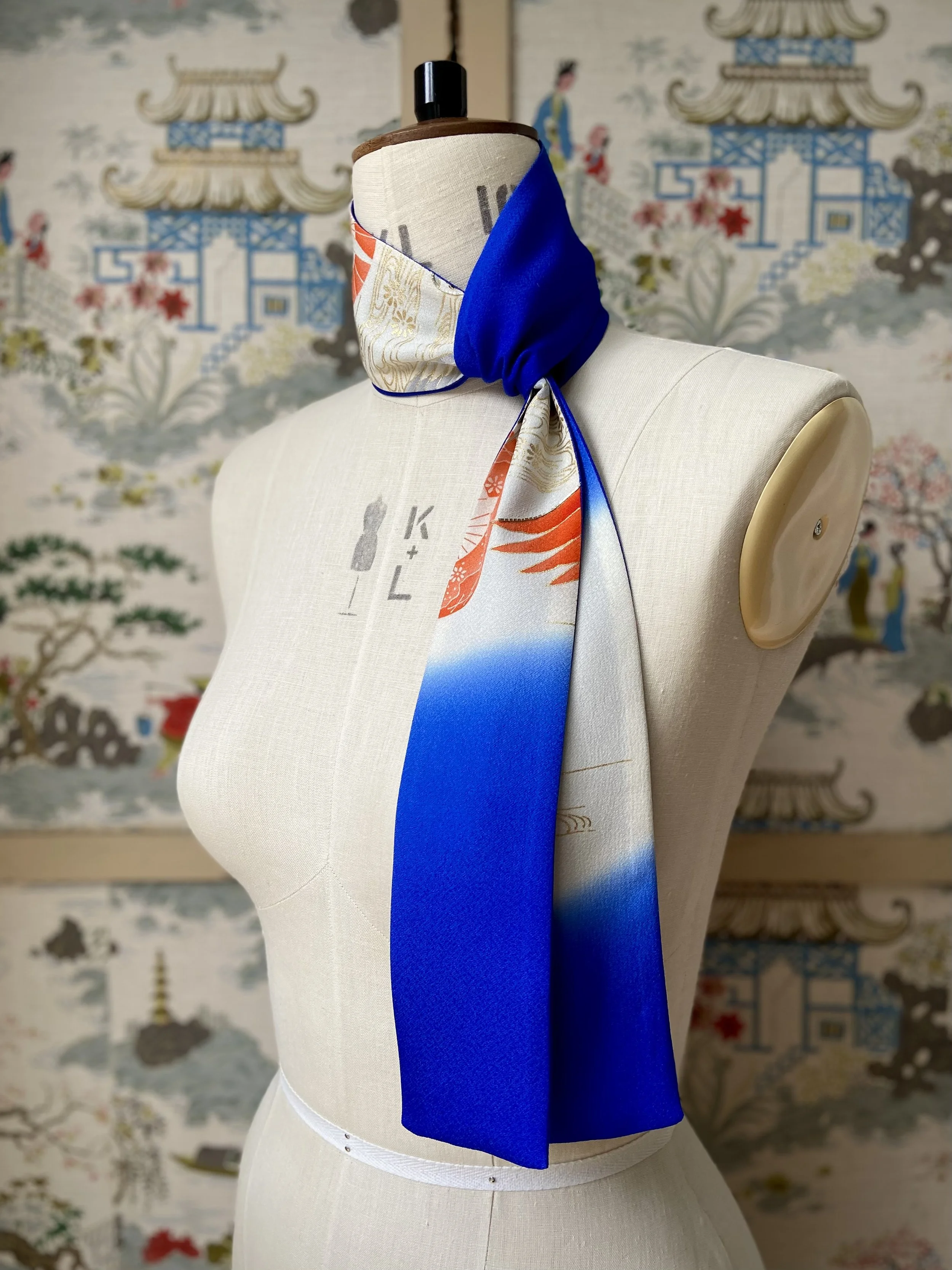 Blue silk scarf, presented on a dress stand, with printed Flying Crane design handmade by Kirsty Chivers