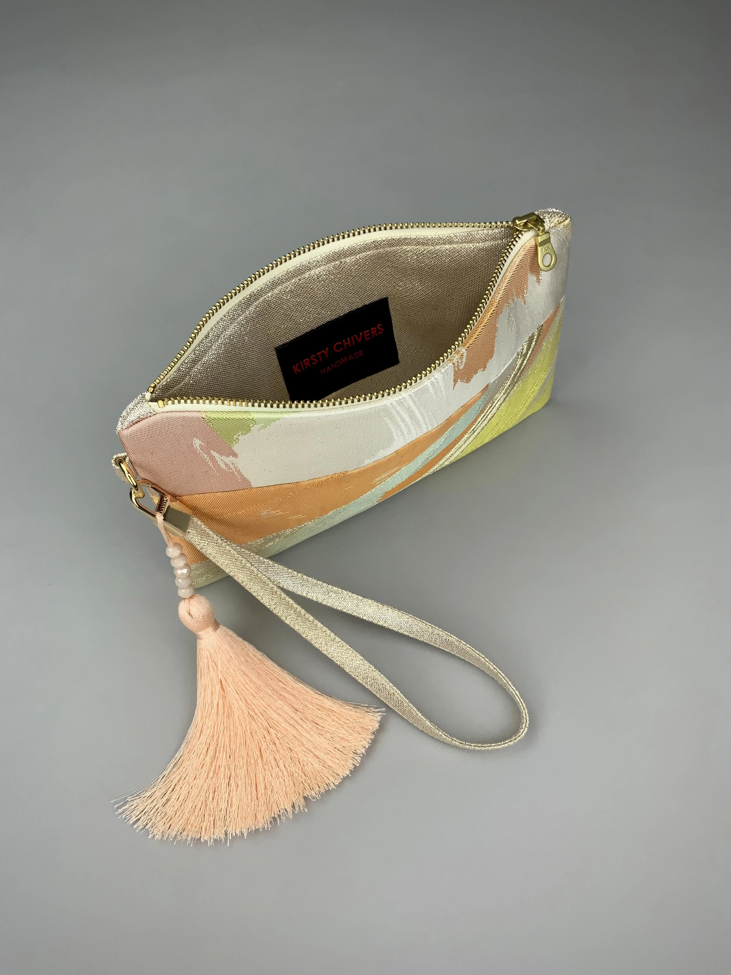 Inside view of wristlet purse made from repurposed vintage obi fabric with brushstroke pastel design and gold-silver threads