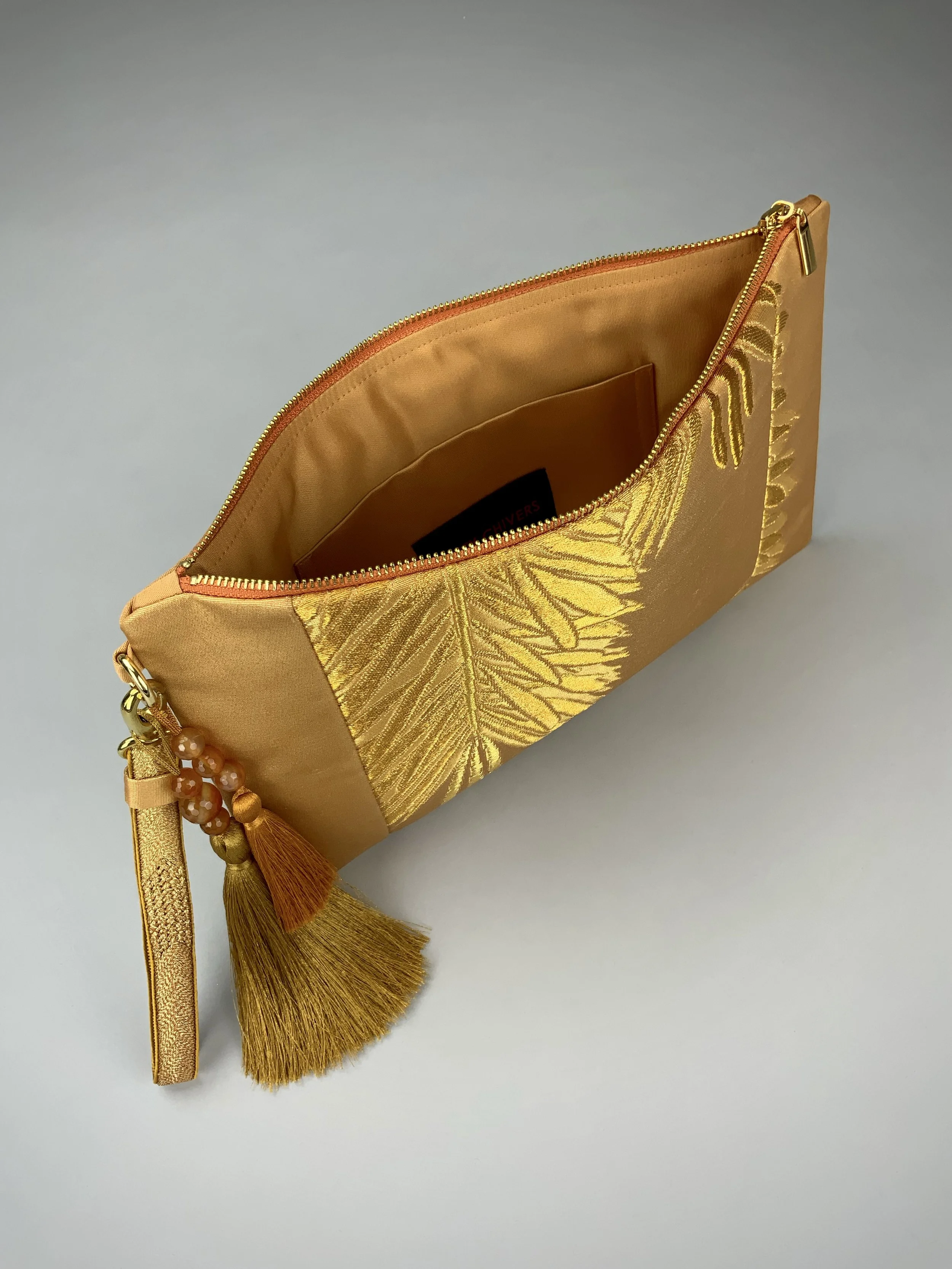 Interior view of glittery gold clutch with abstract leaf design. Handmade from vintage obi silk by Kirsty Chivers