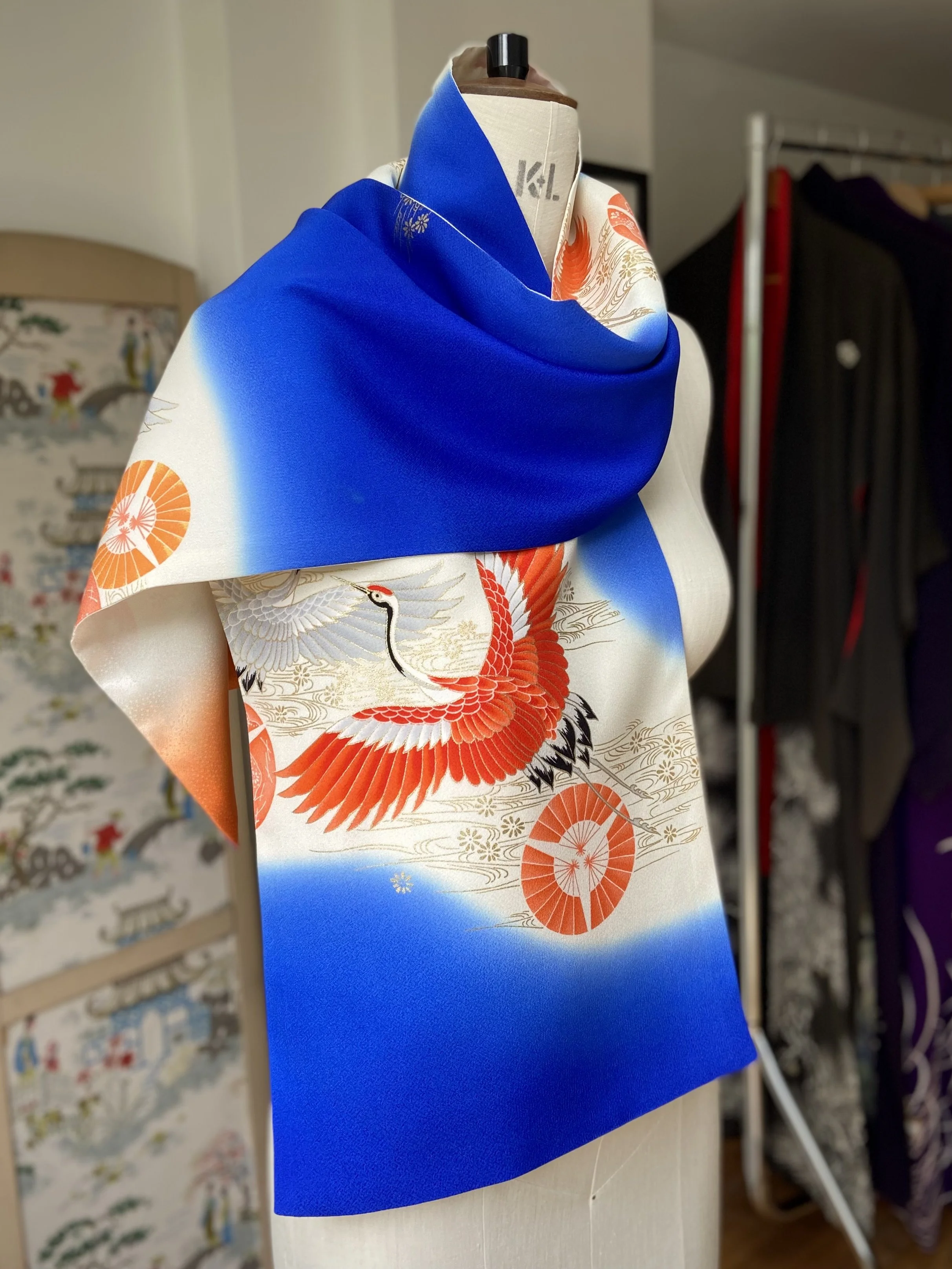 Blue silk scarf, presented on a dress stand, with printed Flying Crane design handmade by Kirsty Chivers