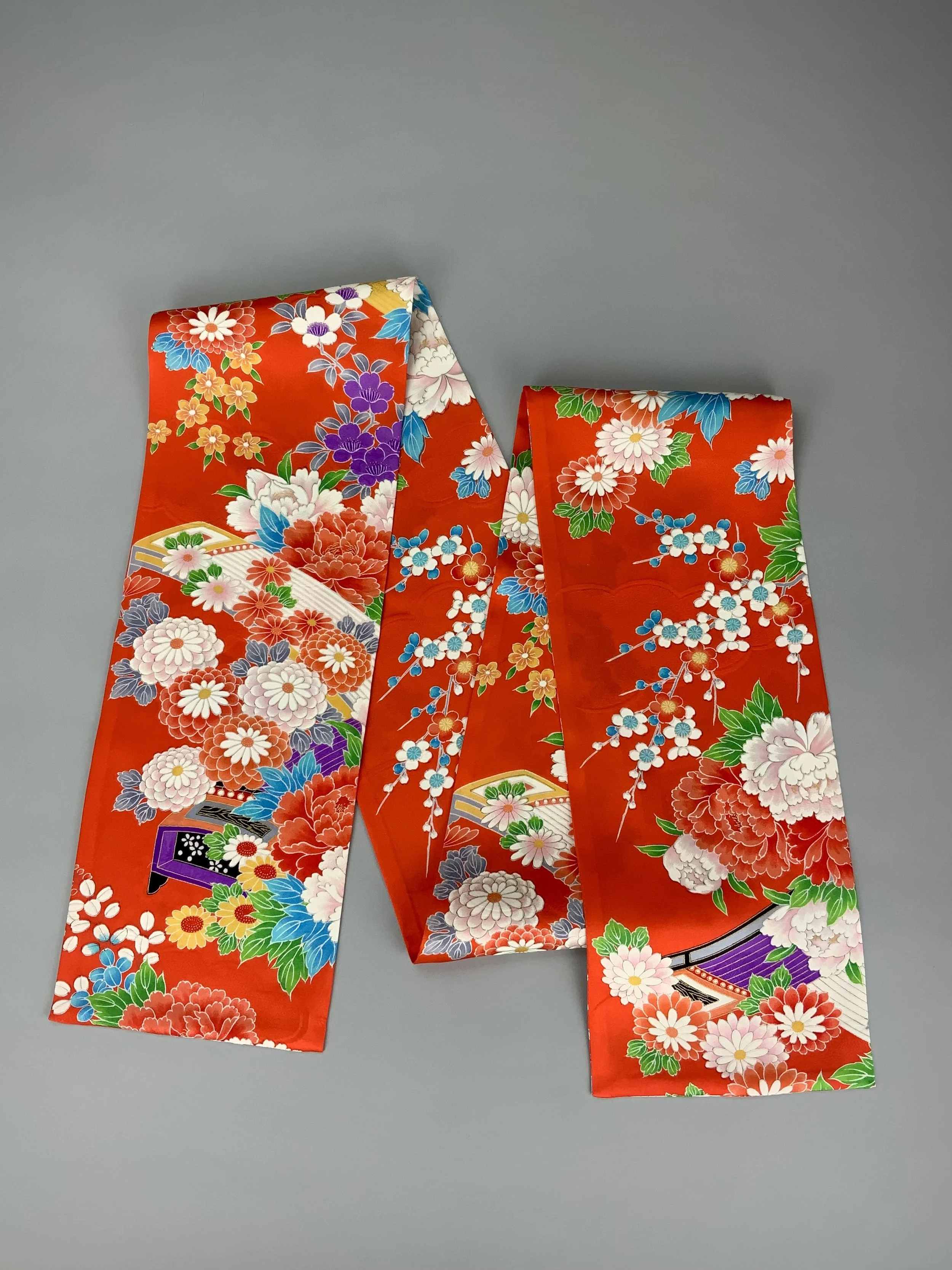A flatlay of orange scarf with blossom print made from rinzu kimono silk by Kirsty Chivers