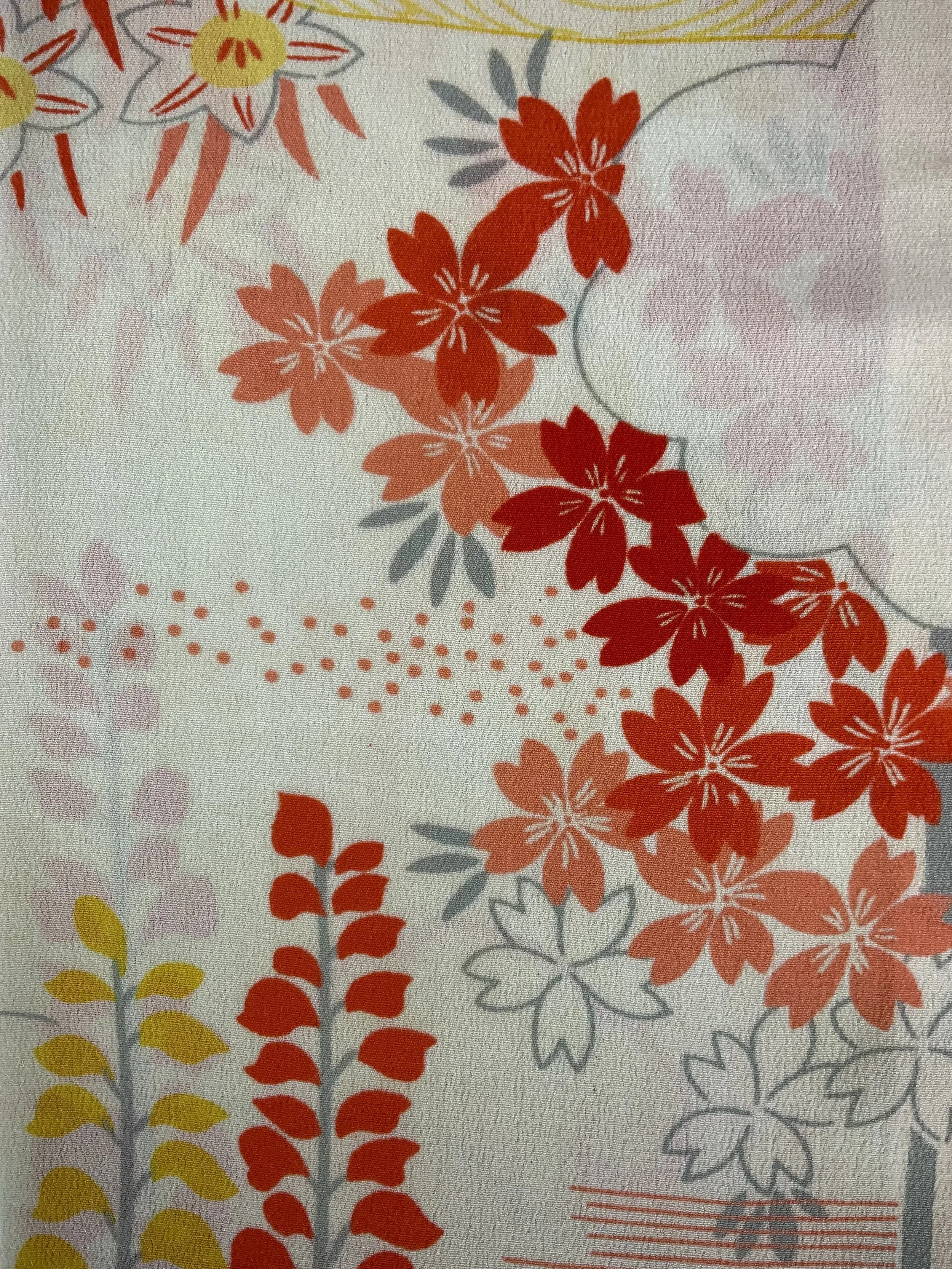 Closeup of vibrant red and yellow scarf with printed blossom design, handmade from repurposed Japanese kimono crepe silk by Kirsty Chivers