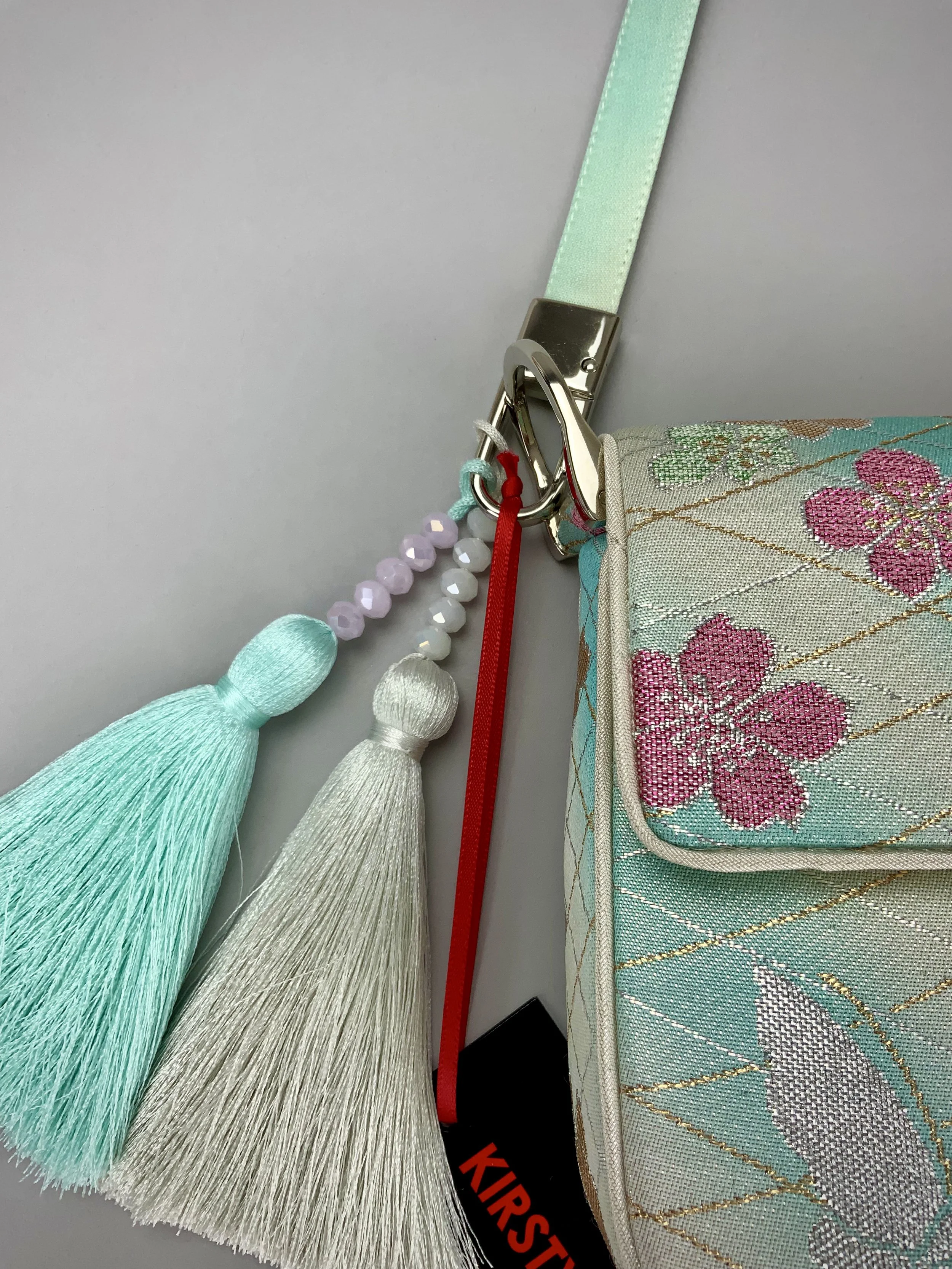 Closeup of aqua ombre evening bag made from vintage obi silk with pastel gold butterfly and blossom design by Kirsty Chivers