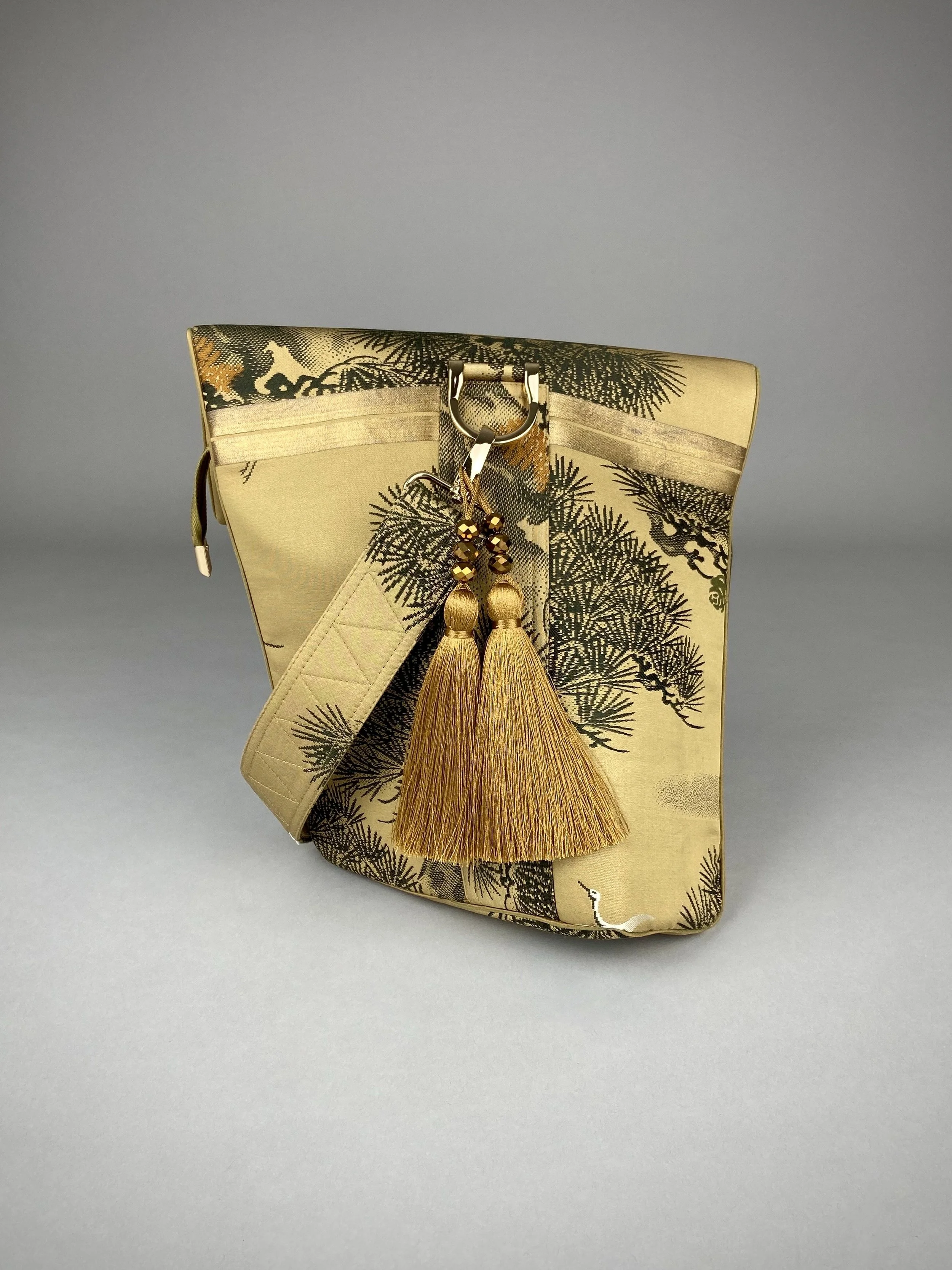 Olive green Matsu pine vintage obi silk shoulder bag with crane design, gold thread detailing and matching fabric tassel charm by Kirsty Chivers