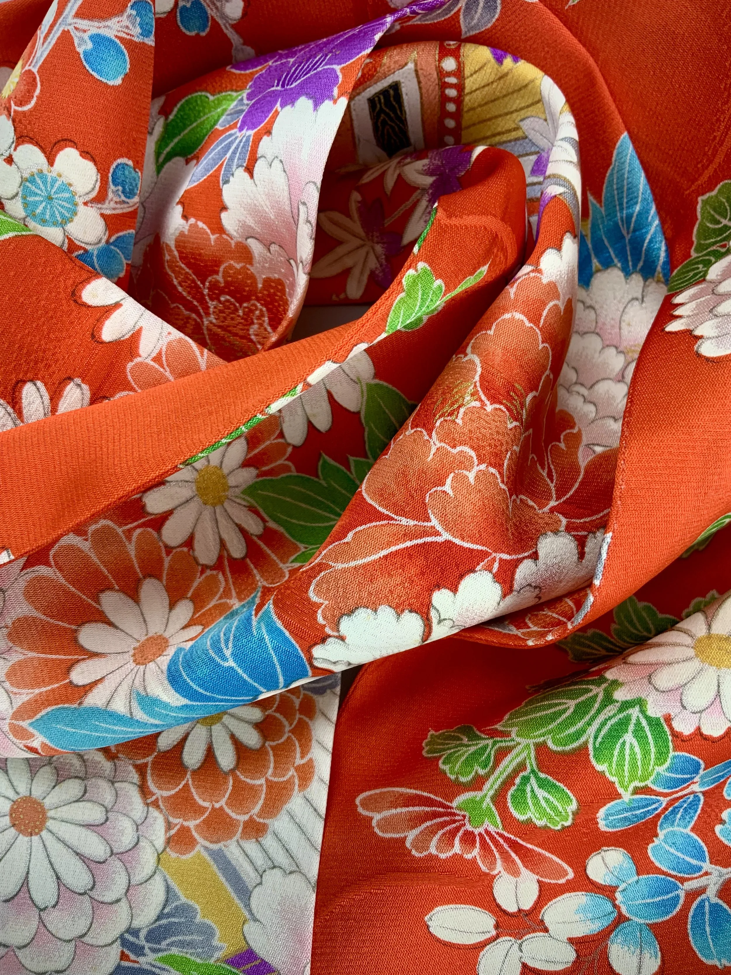 Closeup of orange scarf with blossom print made from rinzu kimono silk by Kirsty Chivers