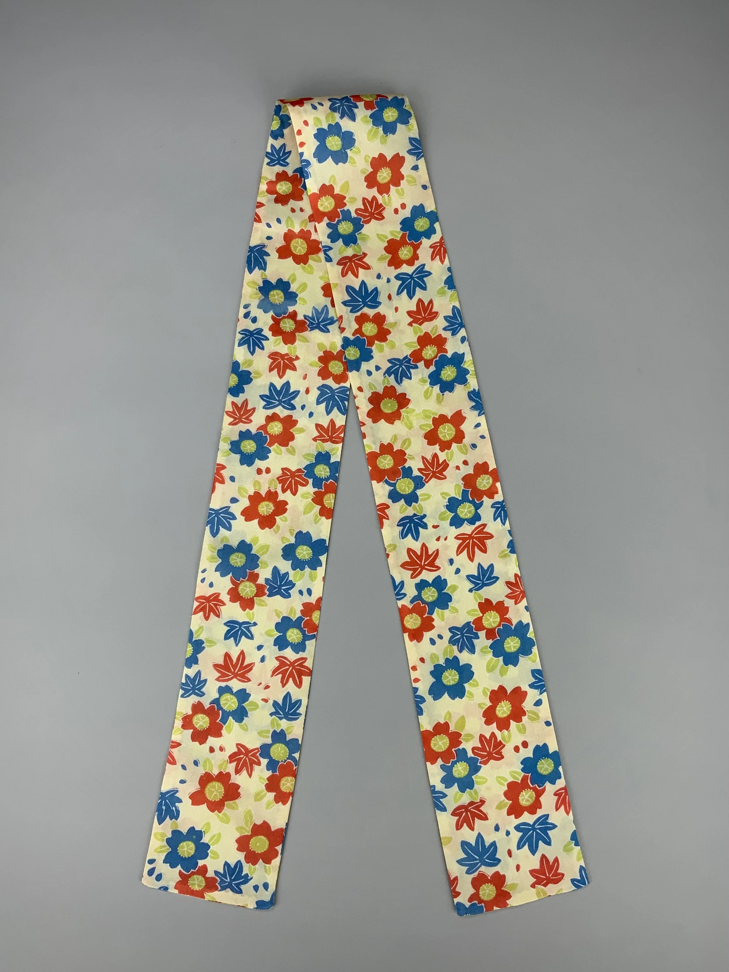 Flatlay of butter yellow skinny scarf with Cherry blossom & Maple leaf print, handmade by Kirsty Chivers