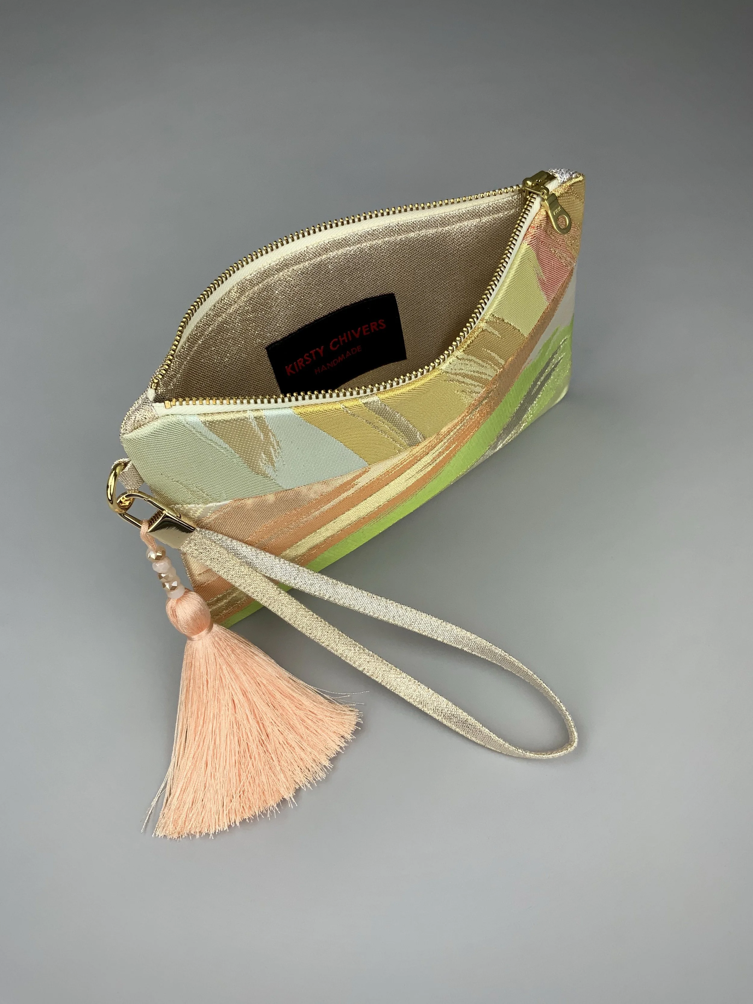 Inside of wristlet purse made from repurposed vintage obi fabric with brushstroke pastel design and gold-silver threads