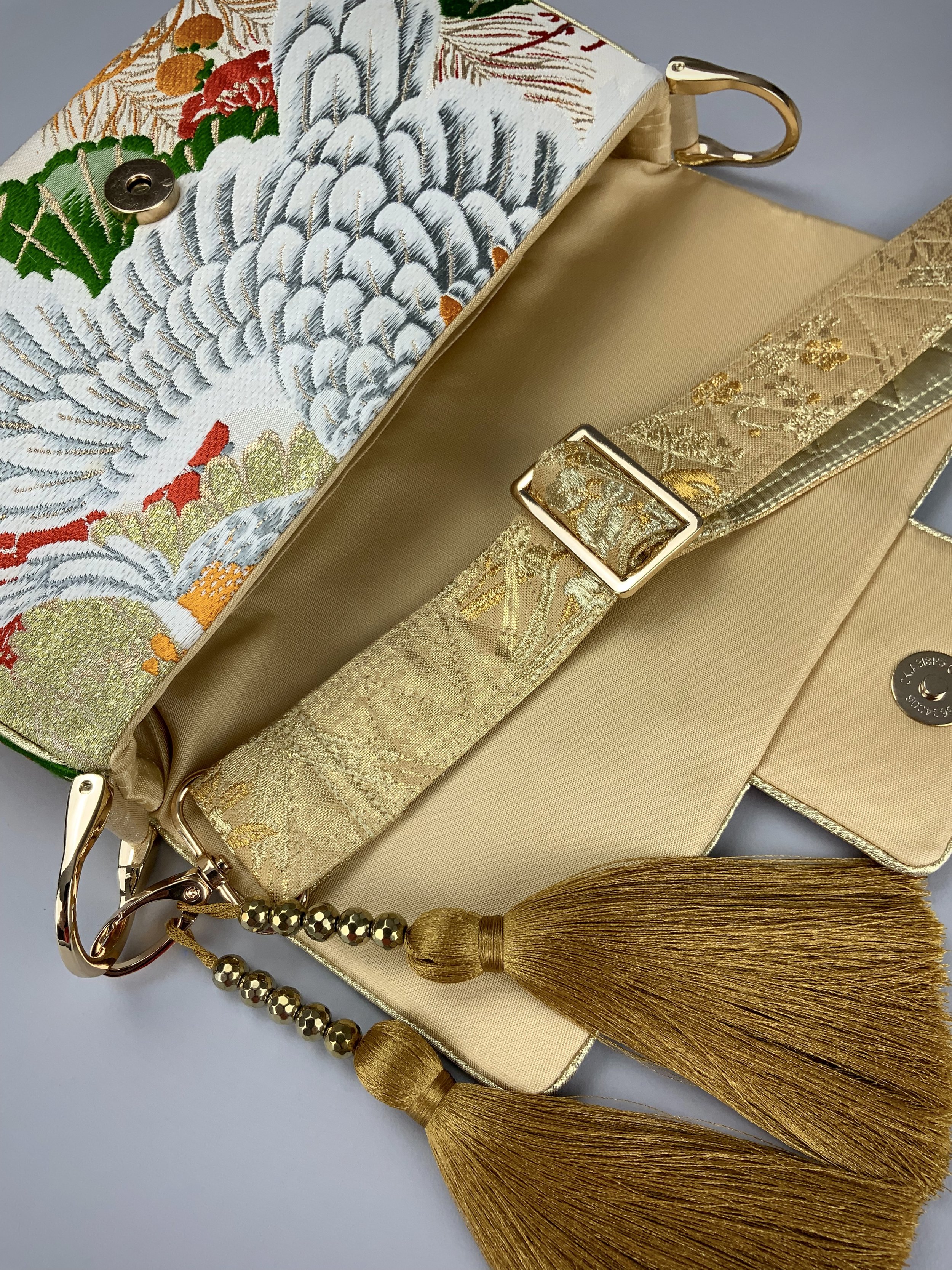 Closeup of unique evening bag in vintage obi silk with peacock, pine motifs & gold accents by Kirsty Chivers