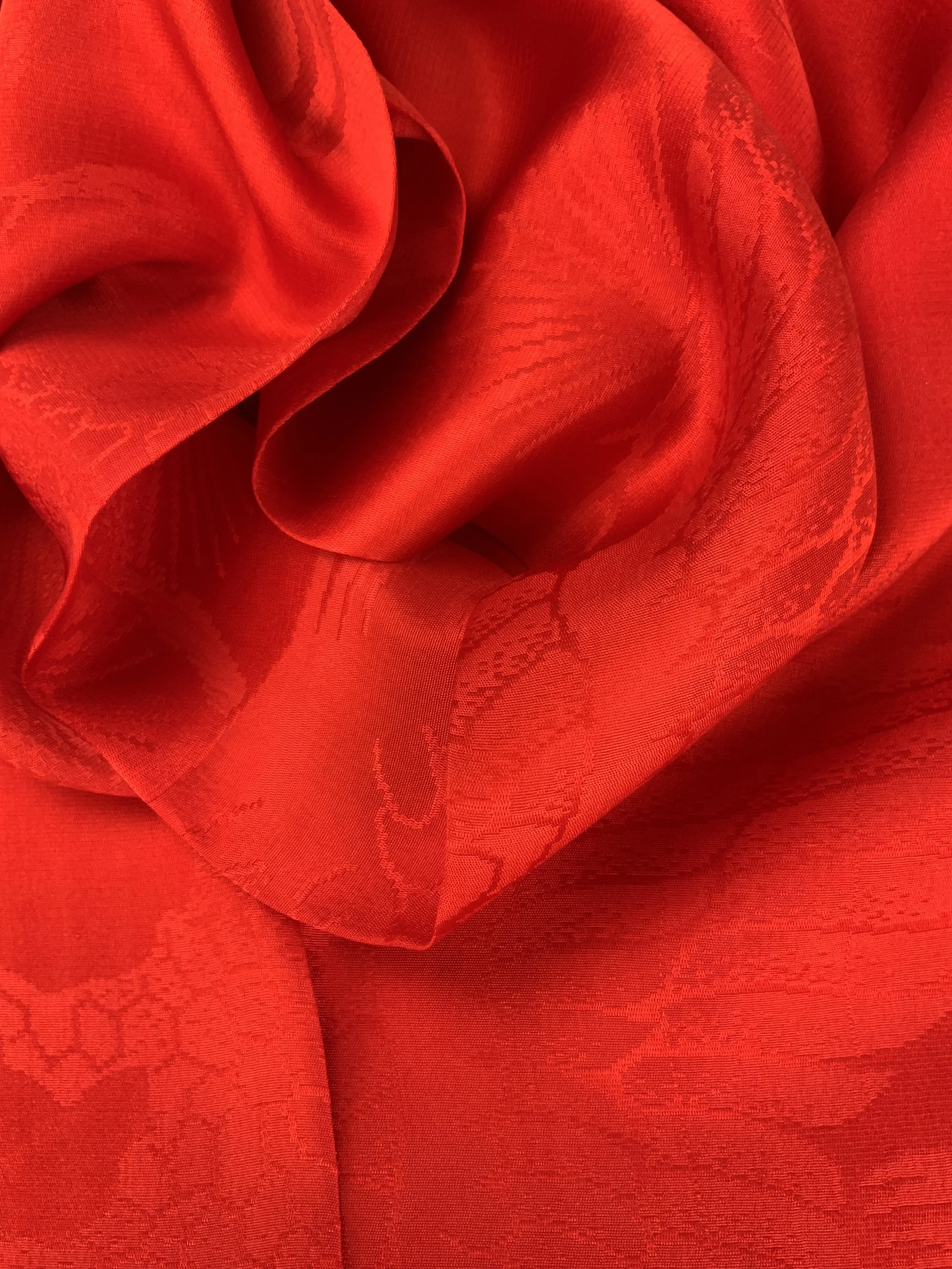 Closeup of a vibrant vermillion red silk scarf crafted from kimono silk by Kirsty Chivers Handmade