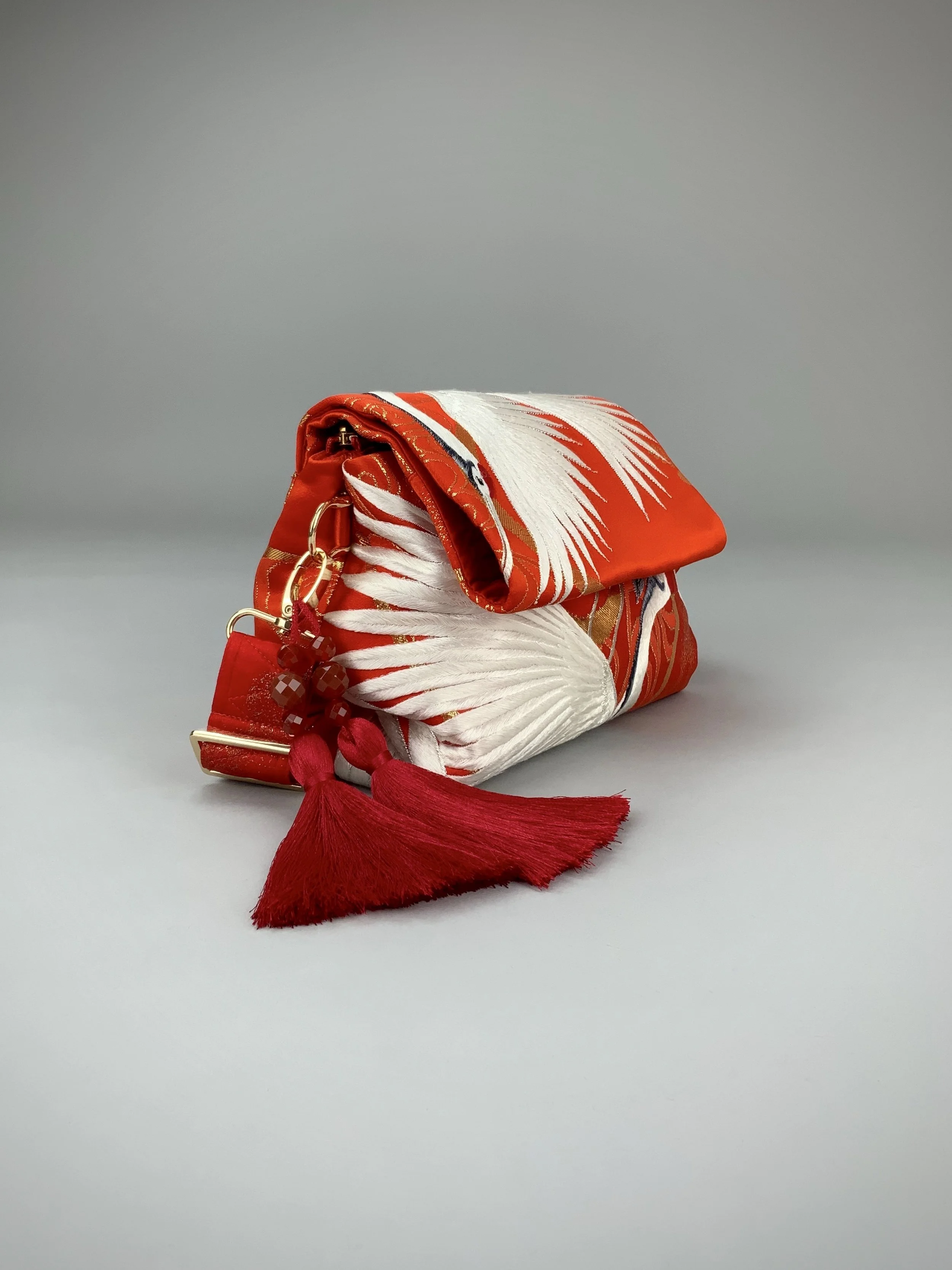 Vermillion red evening bag with embroidered crane design, handmade from vintage kimono silk by Kirsty Chivers