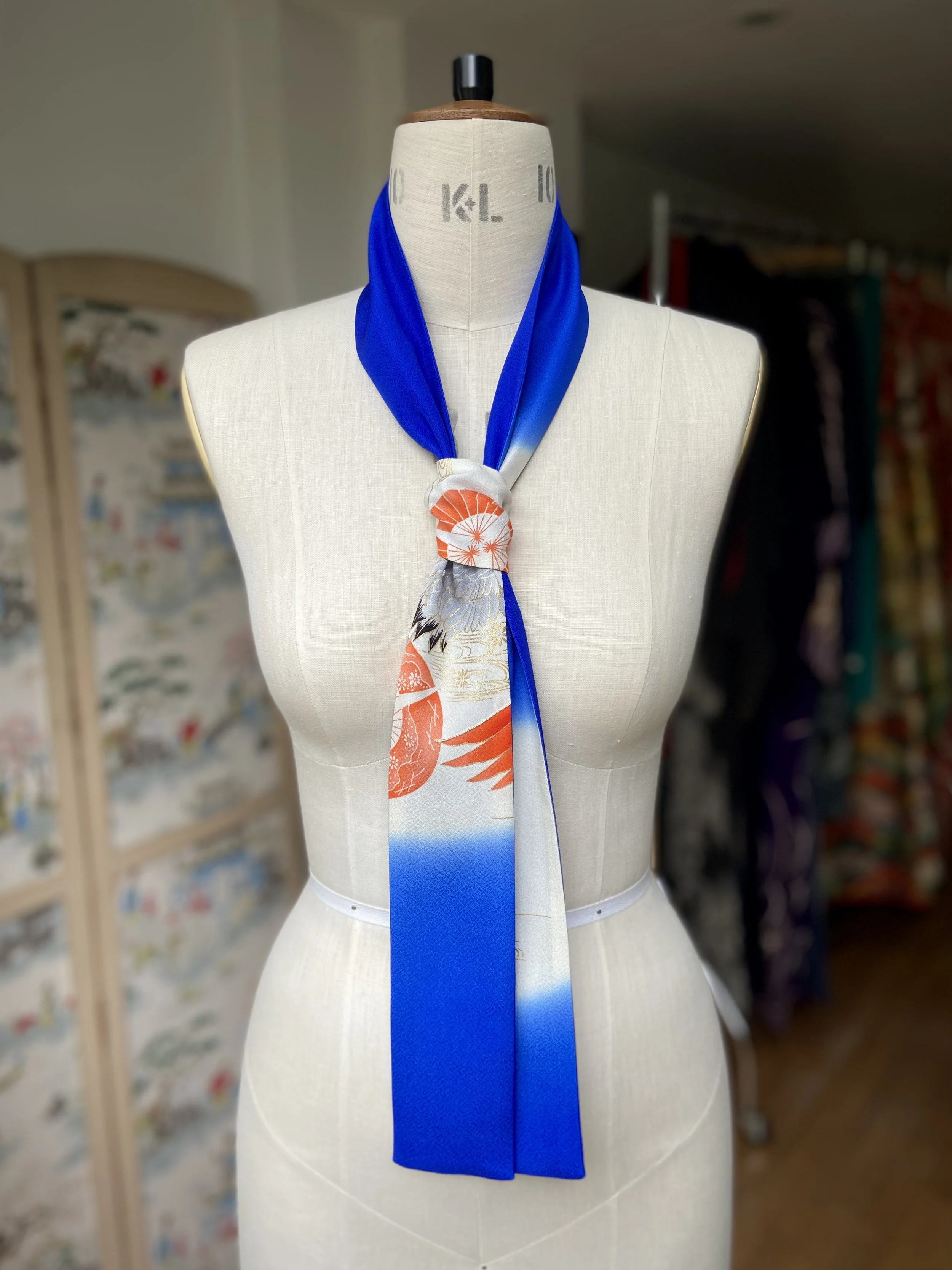 Blue silk scarf, presented on a dress stand, with printed Flying Crane design handmade by Kirsty Chivers