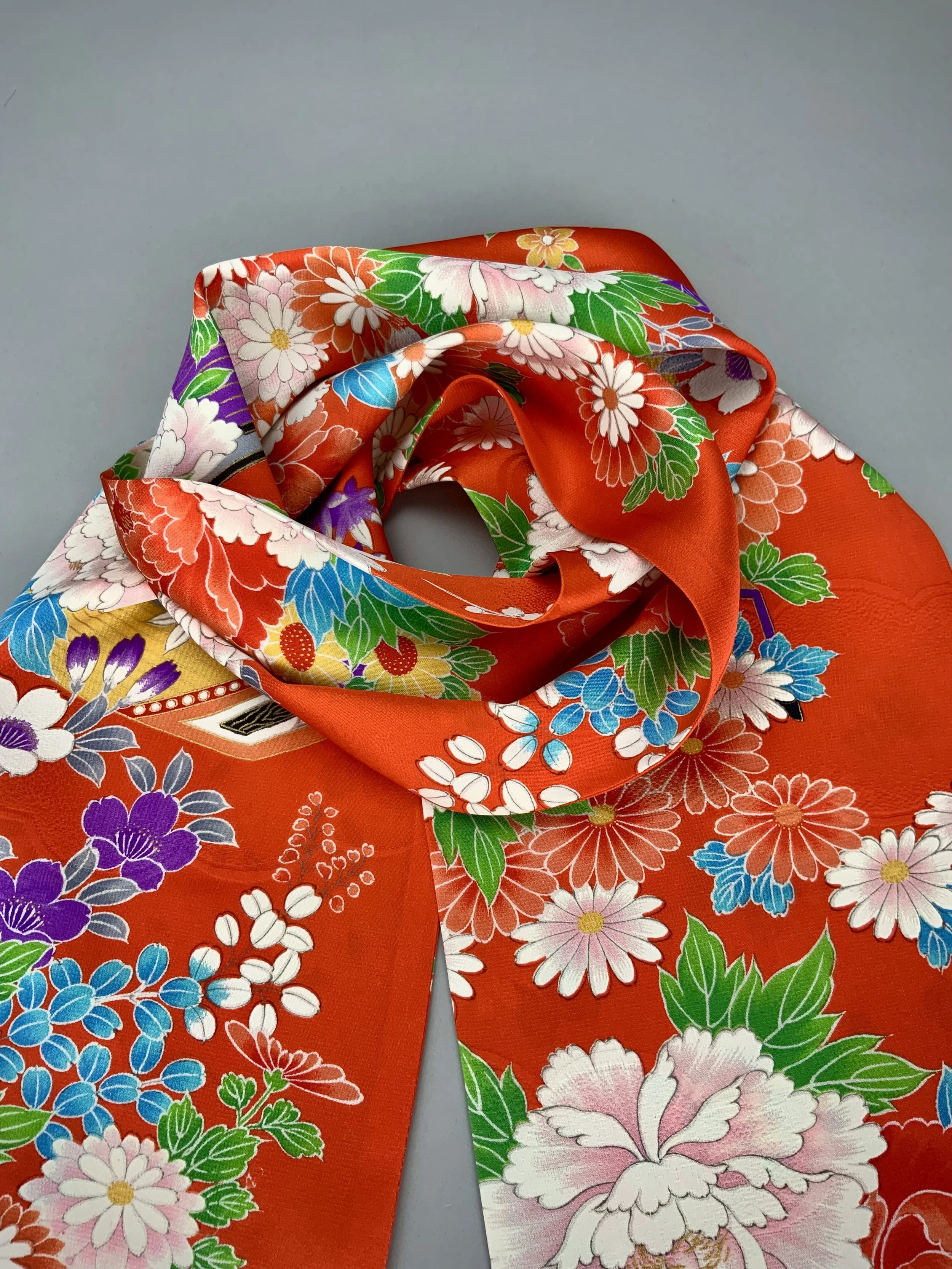 A flatlay of orange scarf with blossom print made from rinzu kimono silk by Kirsty Chivers