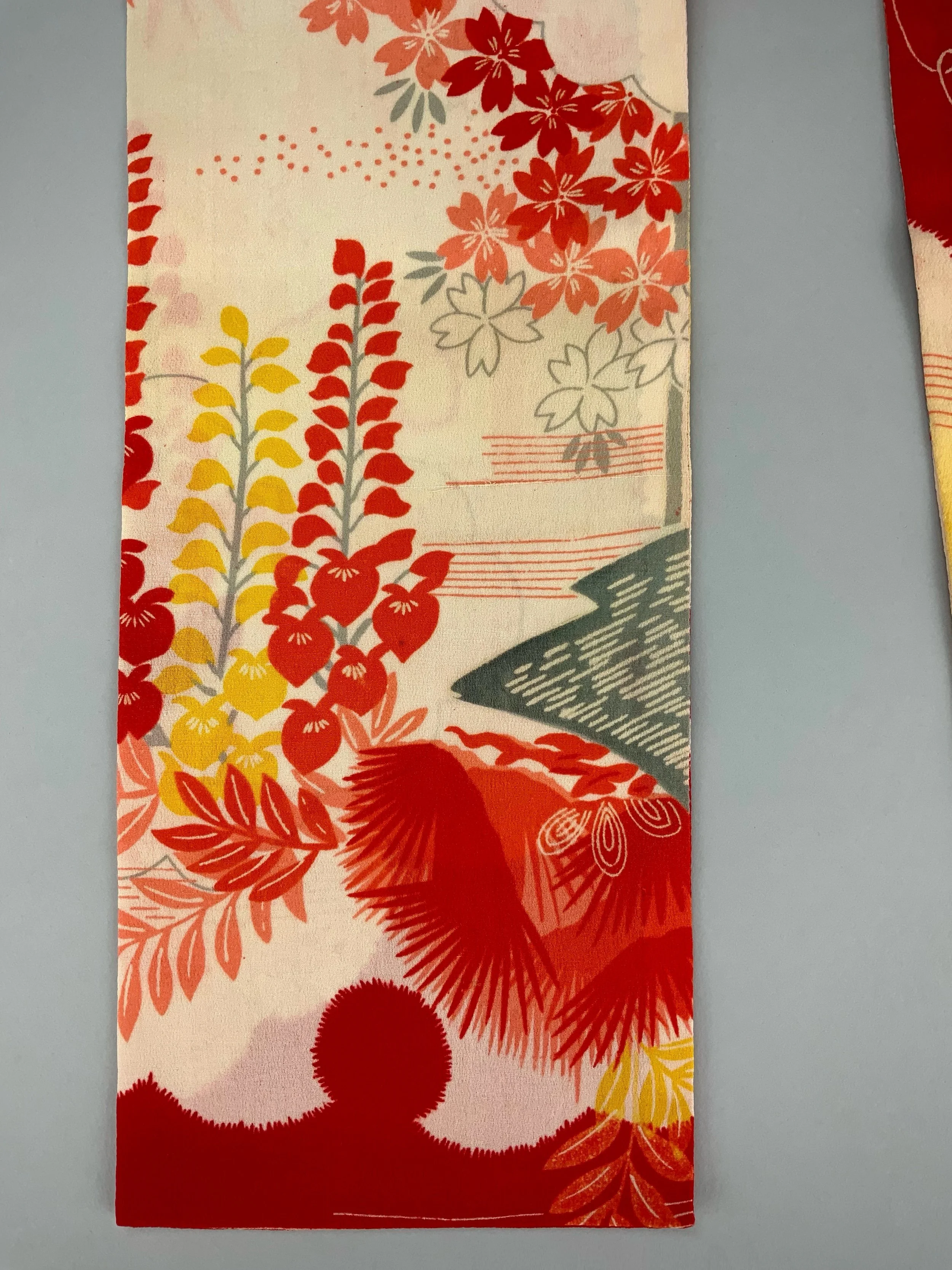 Closeup of vibrant red and yellow scarf with printed blossom design, handmade from repurposed Japanese kimono crepe silk by Kirsty Chivers