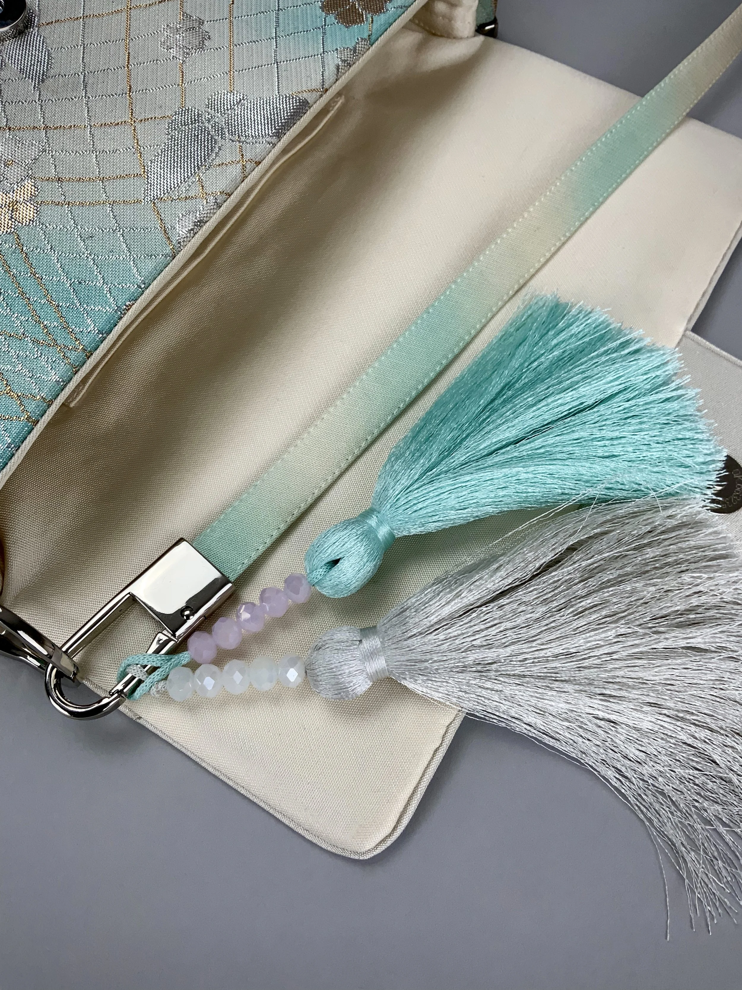 Closeup of aqua ombre evening bag made from vintage obi silk with pastel gold butterfly and blossom design by Kirsty Chivers