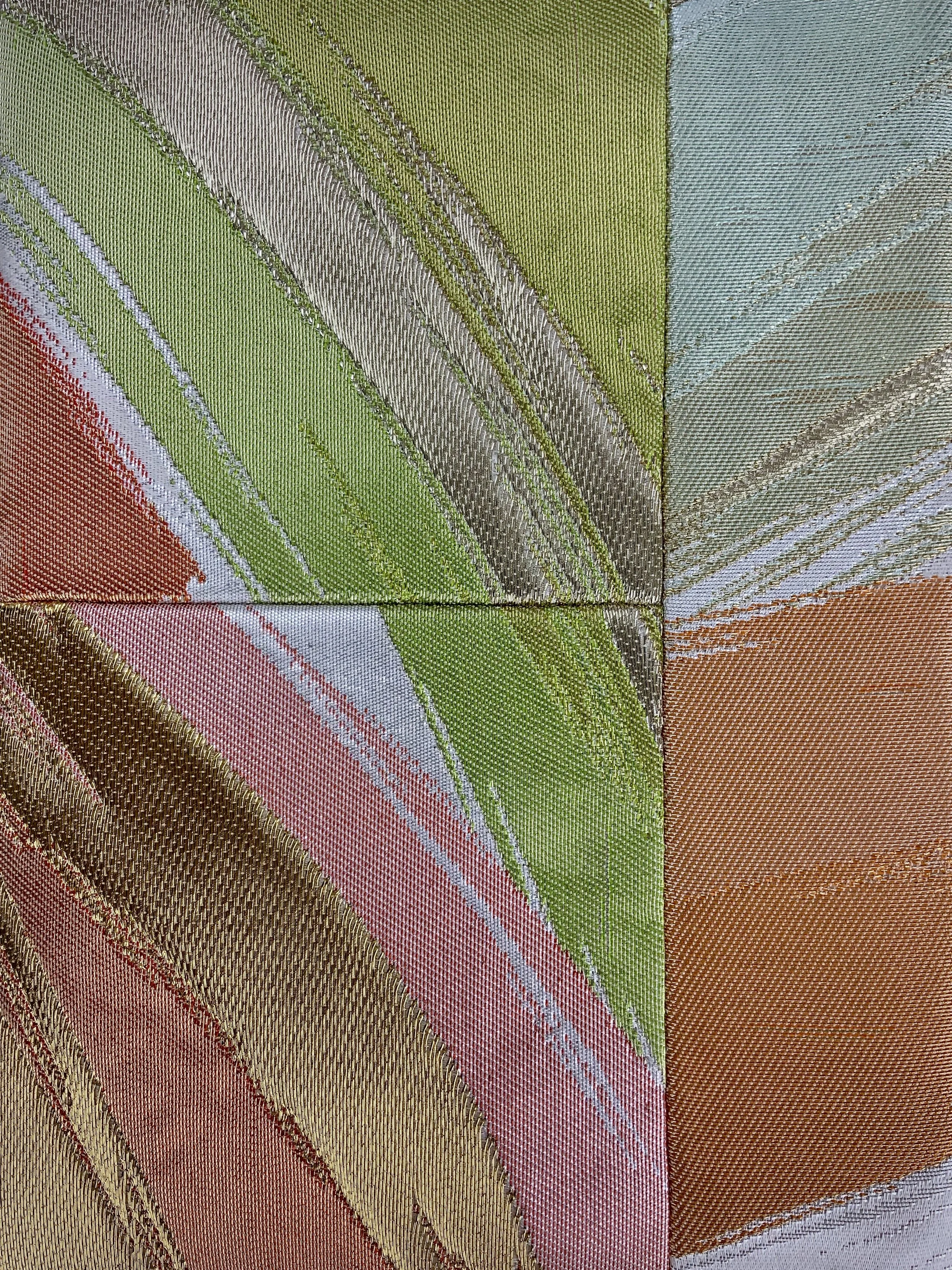 Closeup of wristlet purse made from repurposed vintage obi fabric with brushstroke pastel design and gold-silver threads