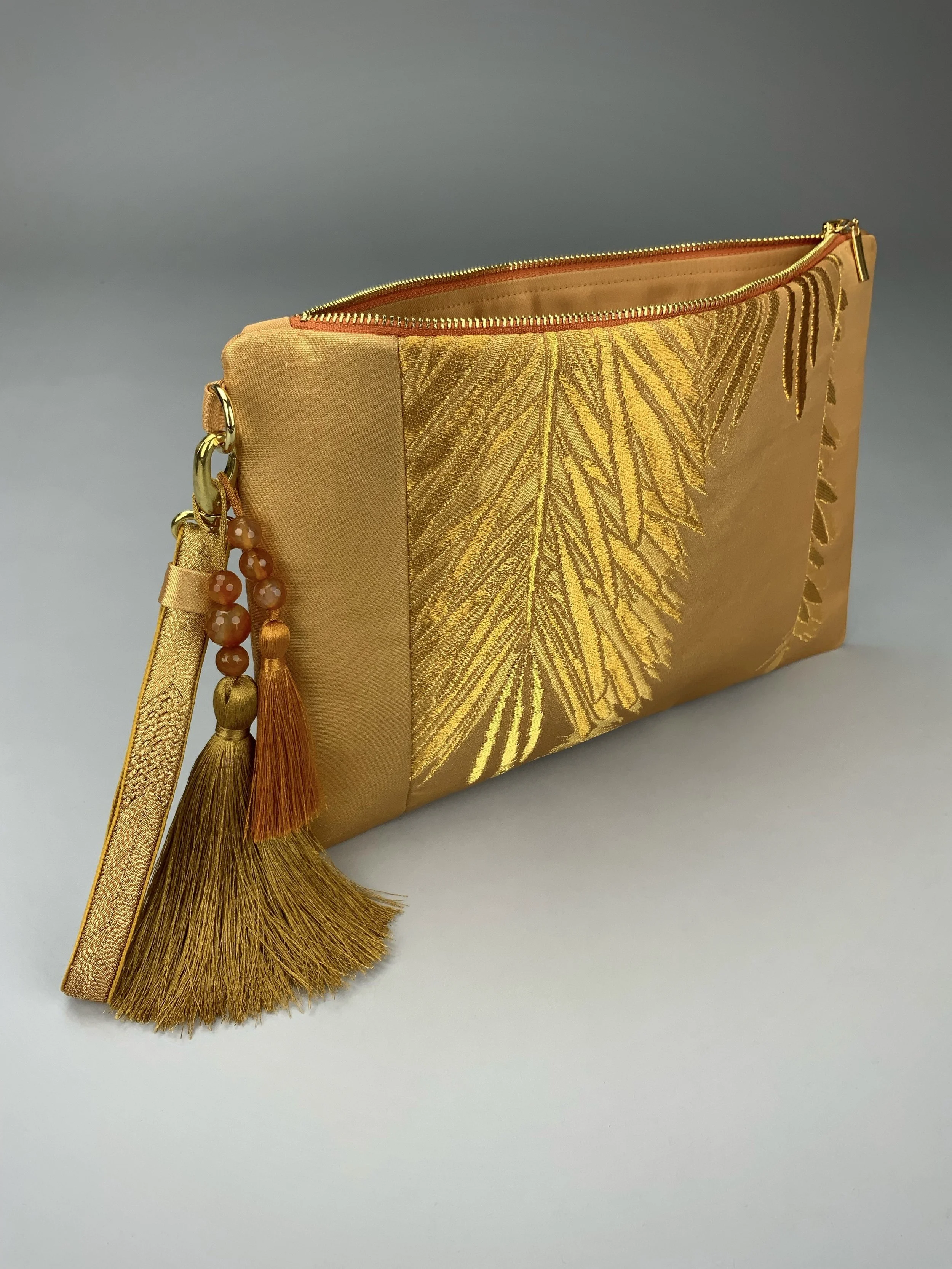 Glittery gold clutch with leaf design and silk tassel charm, handmade from vintage obi silk by Kirsty Chivers