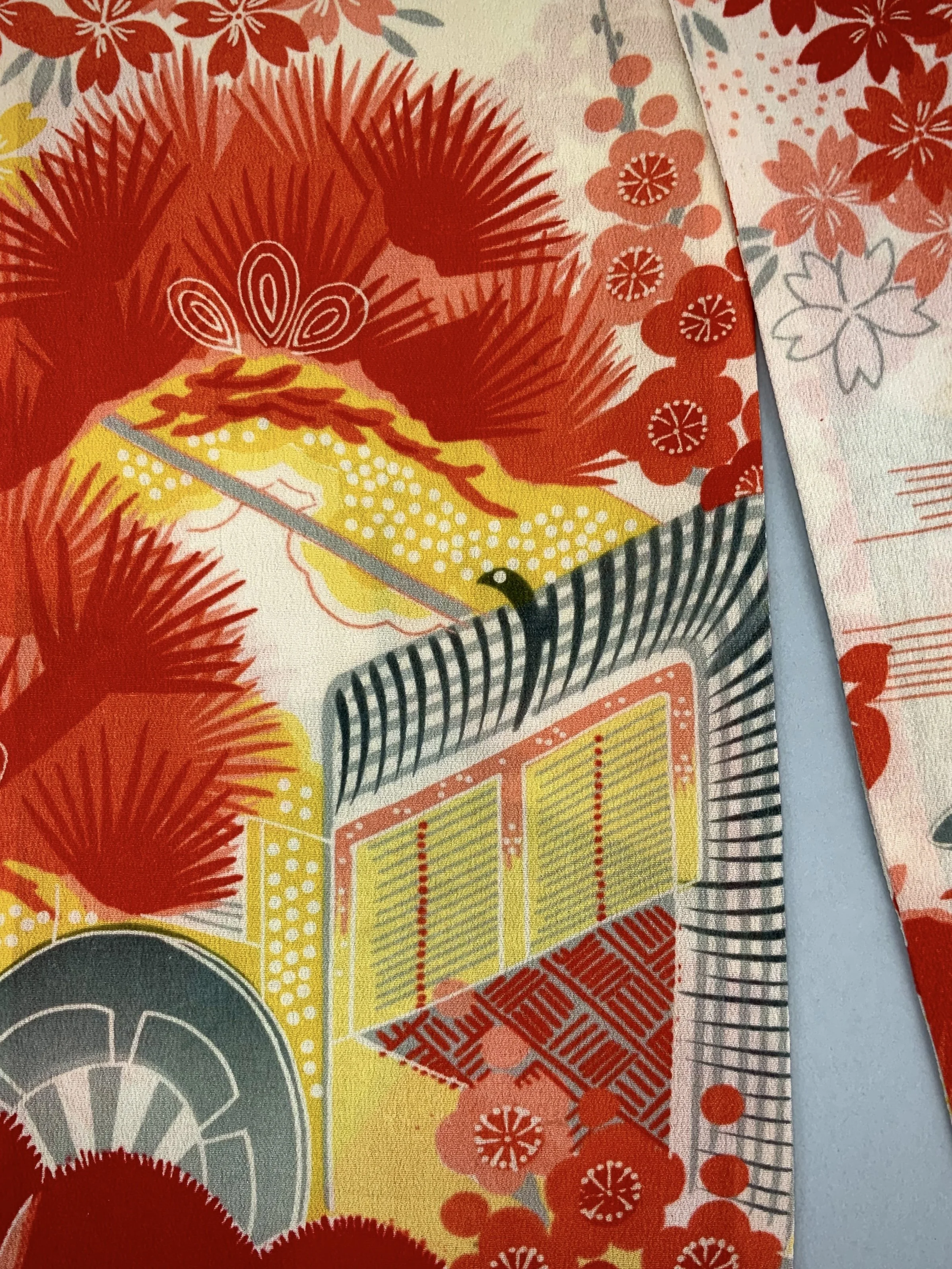 Closeup of vibrant red and yellow scarf with printed blossom design, handmade from repurposed Japanese kimono crepe silk by Kirsty Chivers