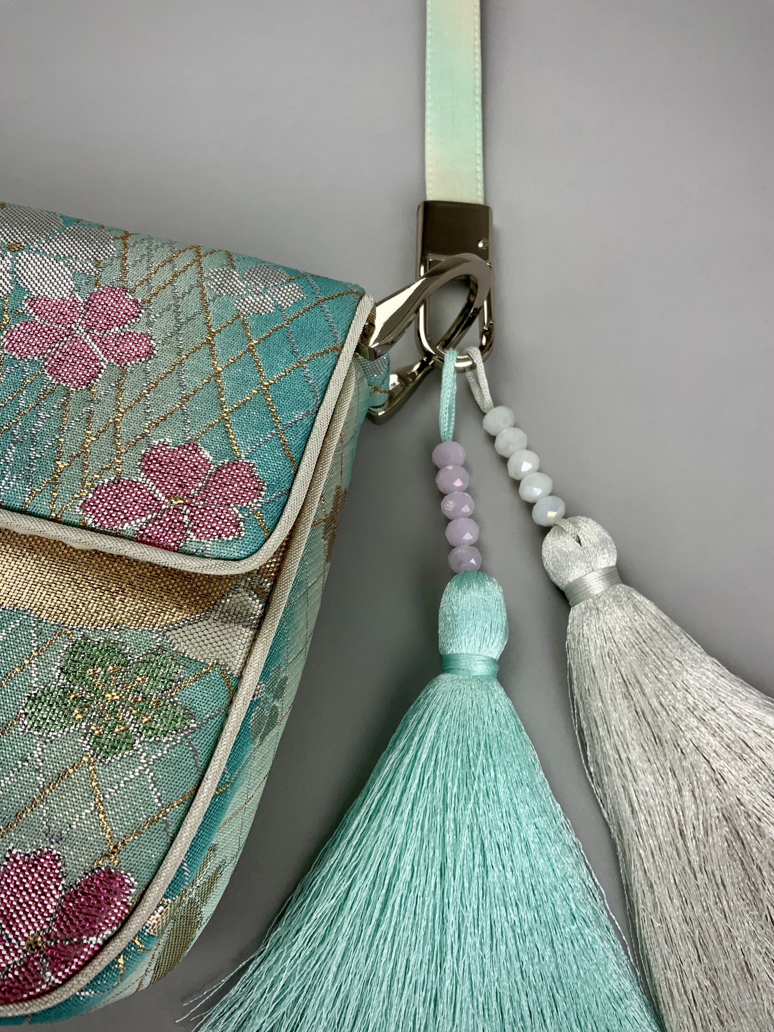 Closeup of aqua ombre evening bag made from vintage obi silk with pastel gold butterfly and blossom design by Kirsty Chivers