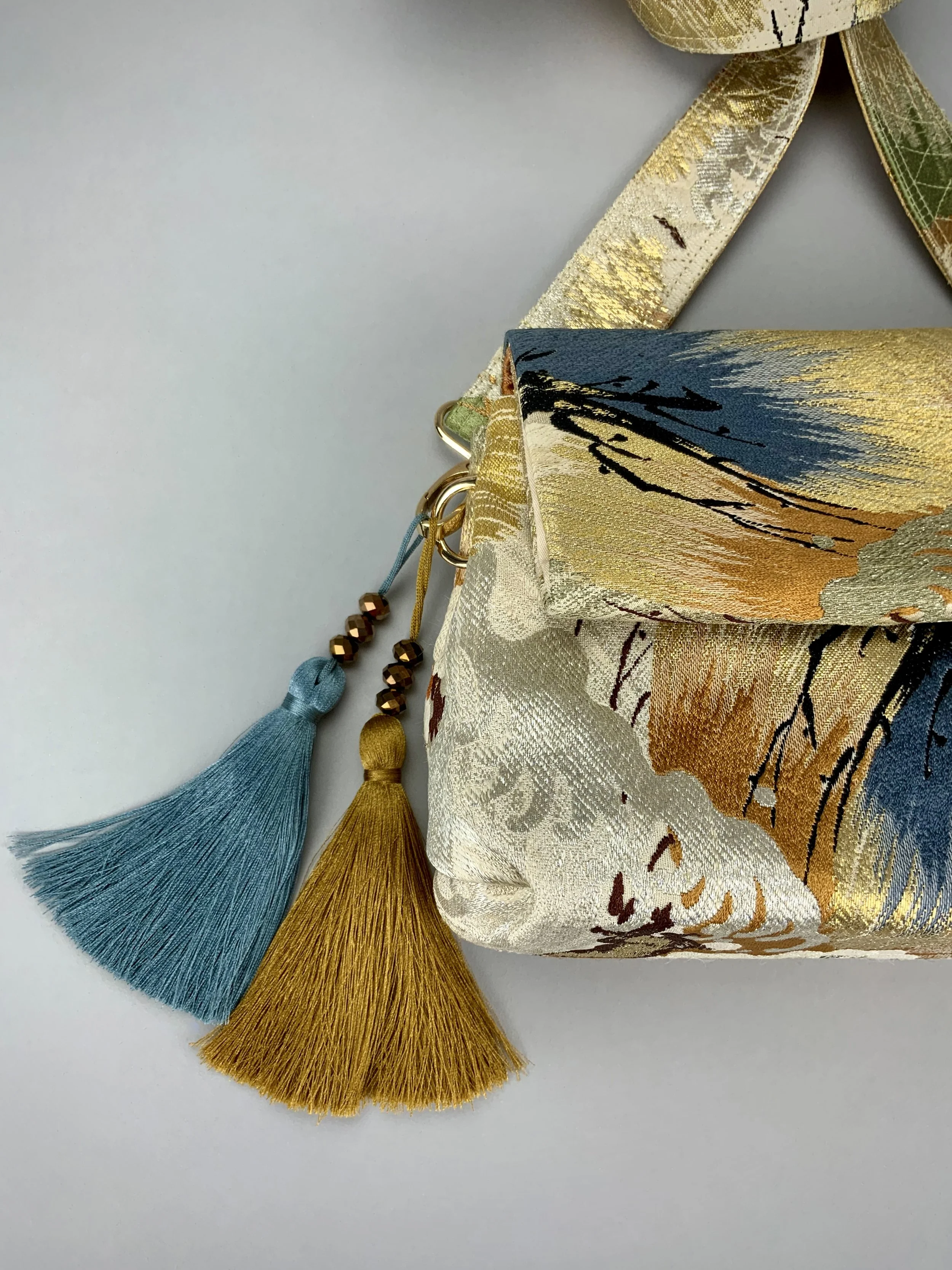 Closeup of metallic gold evening bag with Matsu pine and blossom design, made from vintage obi silk by Kirsty Chivers