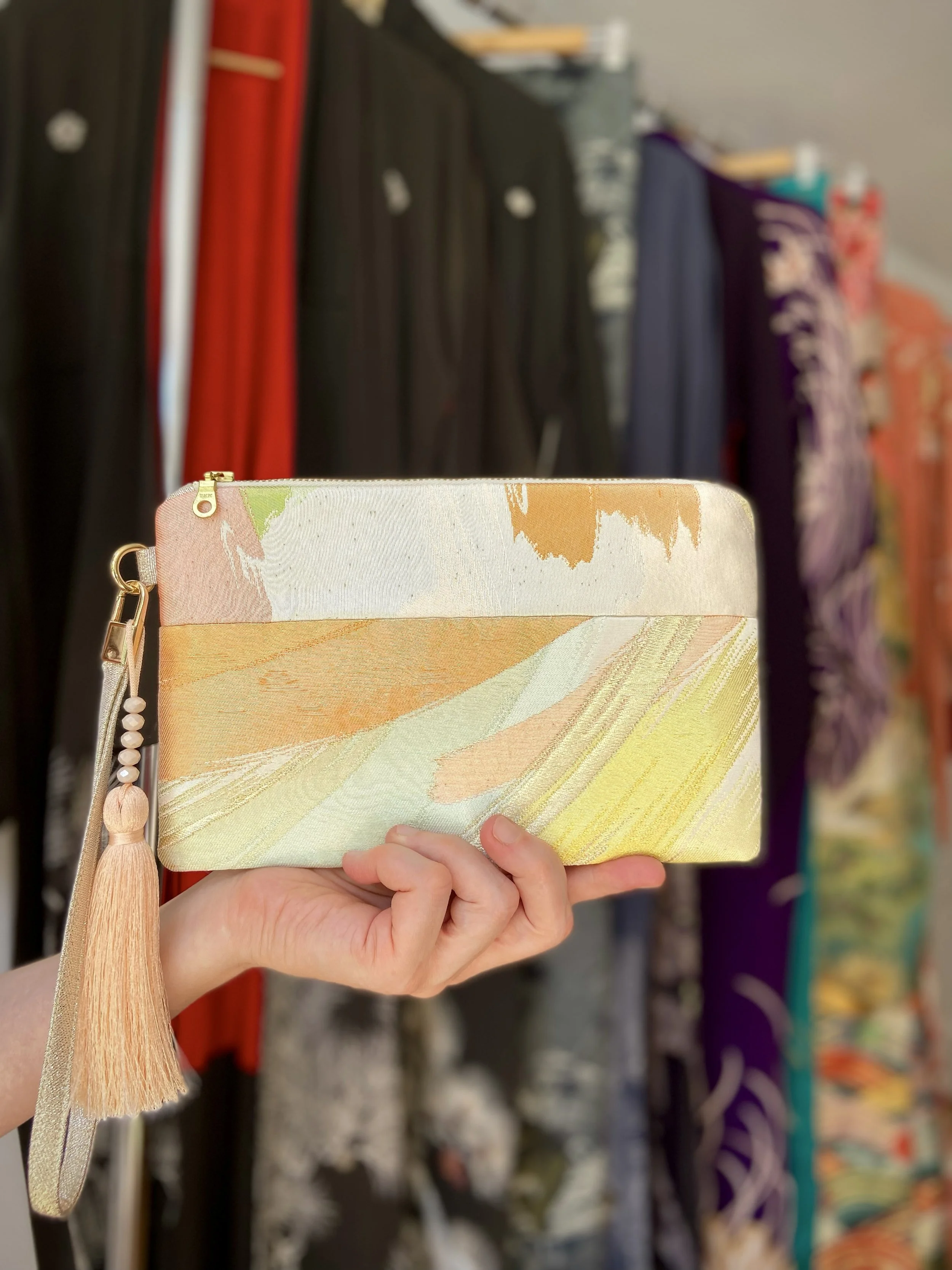 Wristlet purse made from repurposed vintage obi fabric with brushstroke pastel design and gold-silver threads