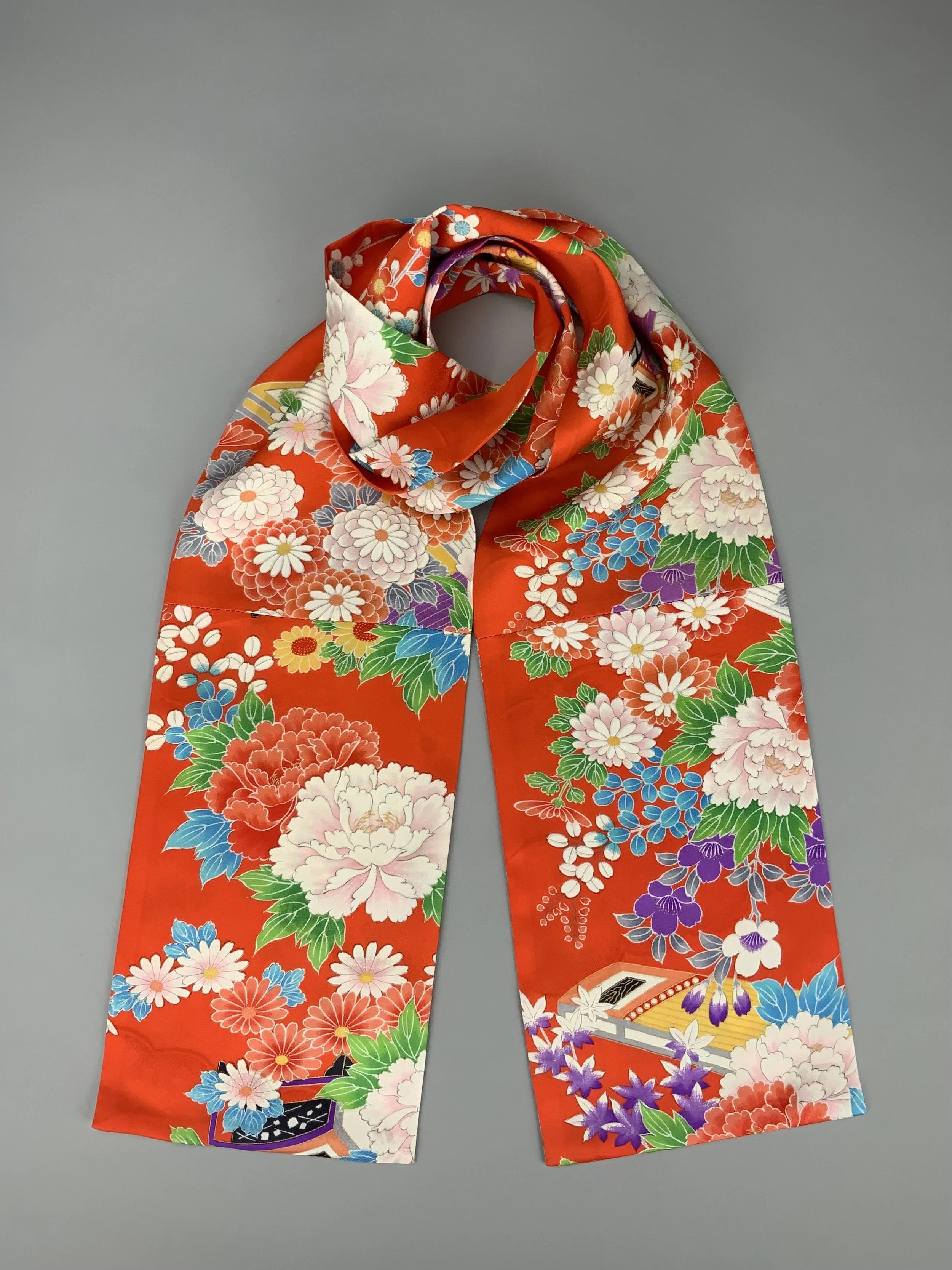 A flatlay of orange scarf with blossom print made from rinzu kimono silk by Kirsty Chivers