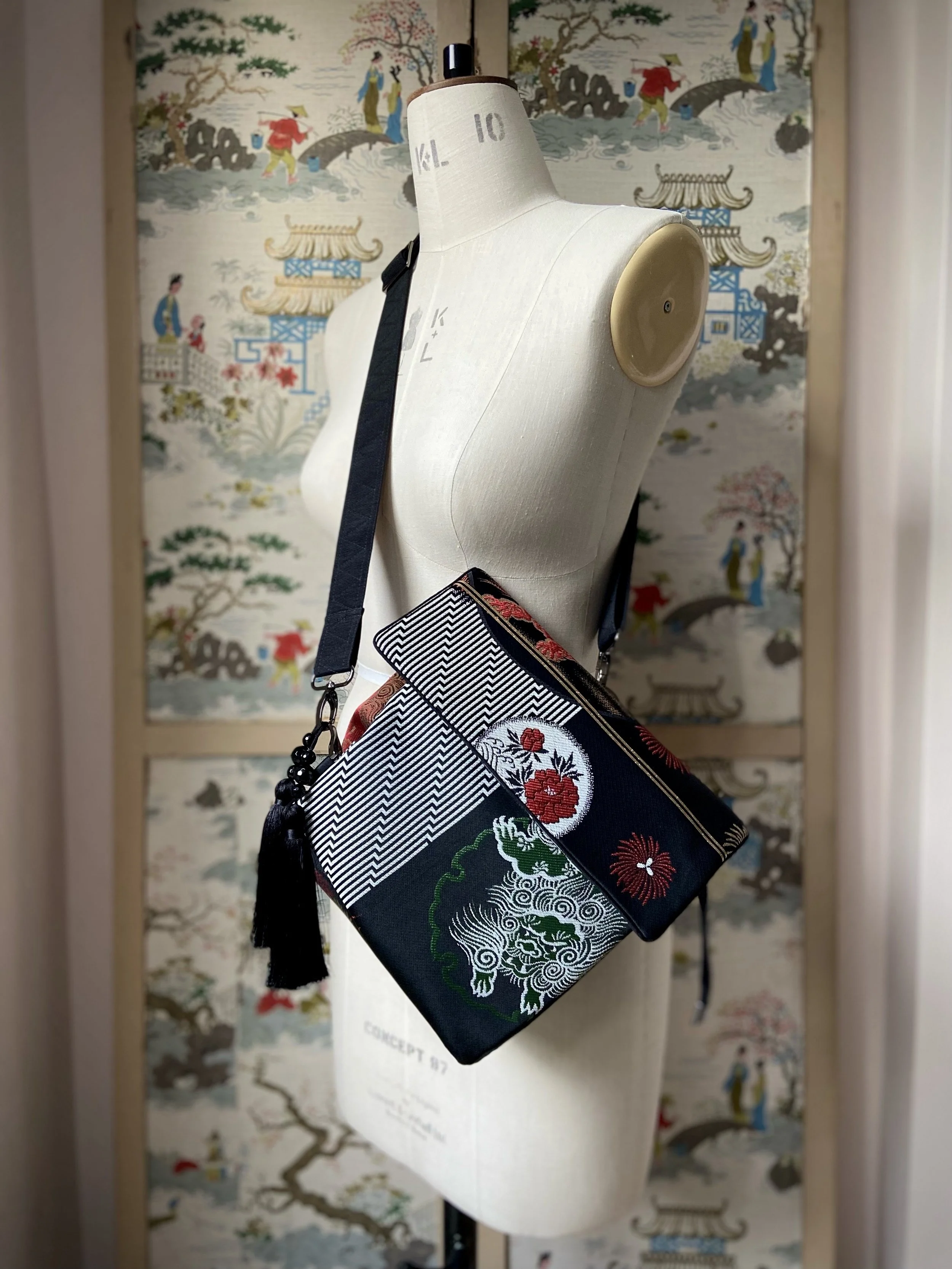 Black matt satin silk and rayon obi bag with red, green, gold and ivory dragon motifs, gunmetal hardware and black tassel charm by Kirsty Chivers