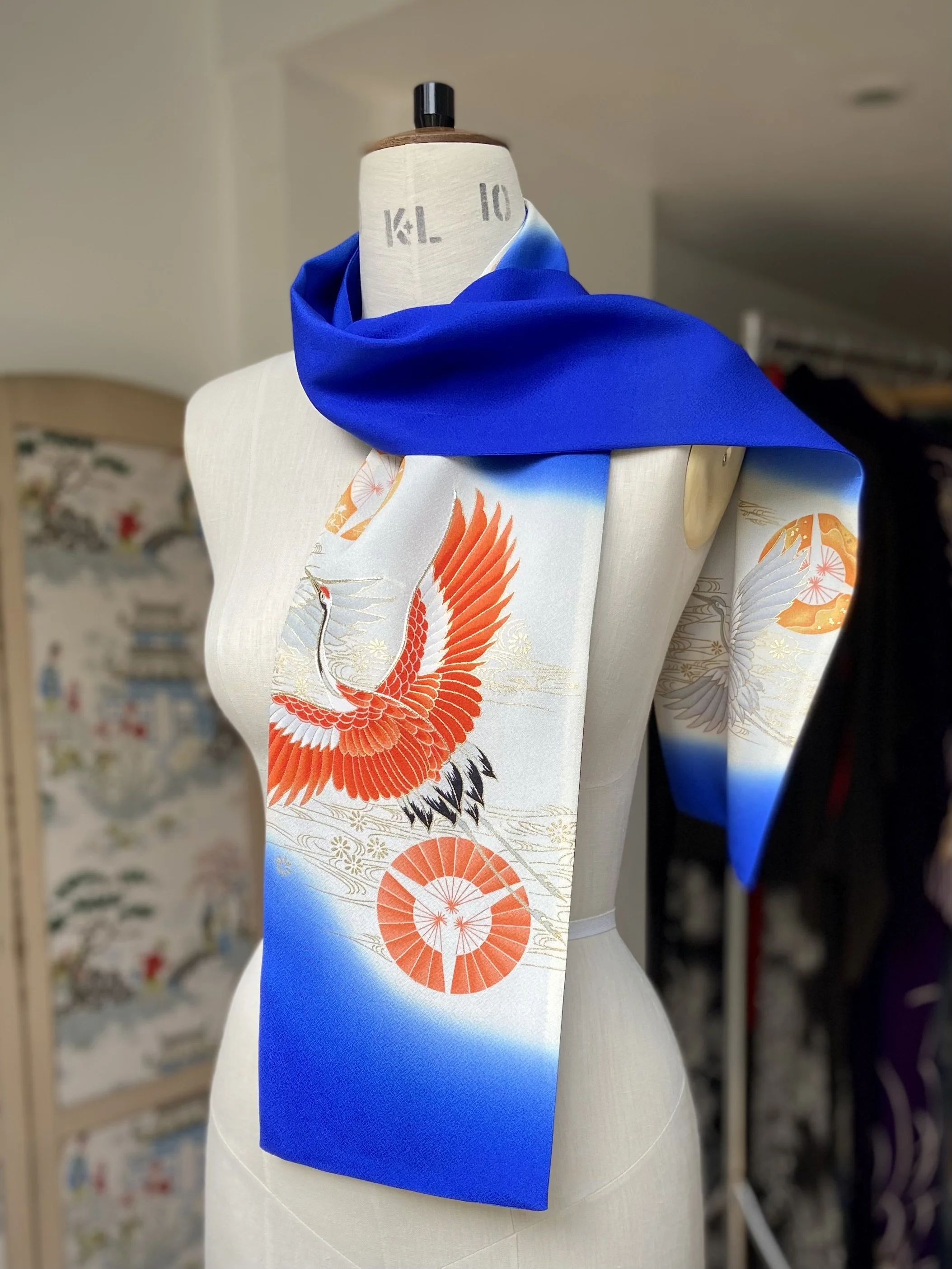 Blue silk scarf, presented on a dress stand, with printed Flying Crane design handmade by Kirsty Chivers