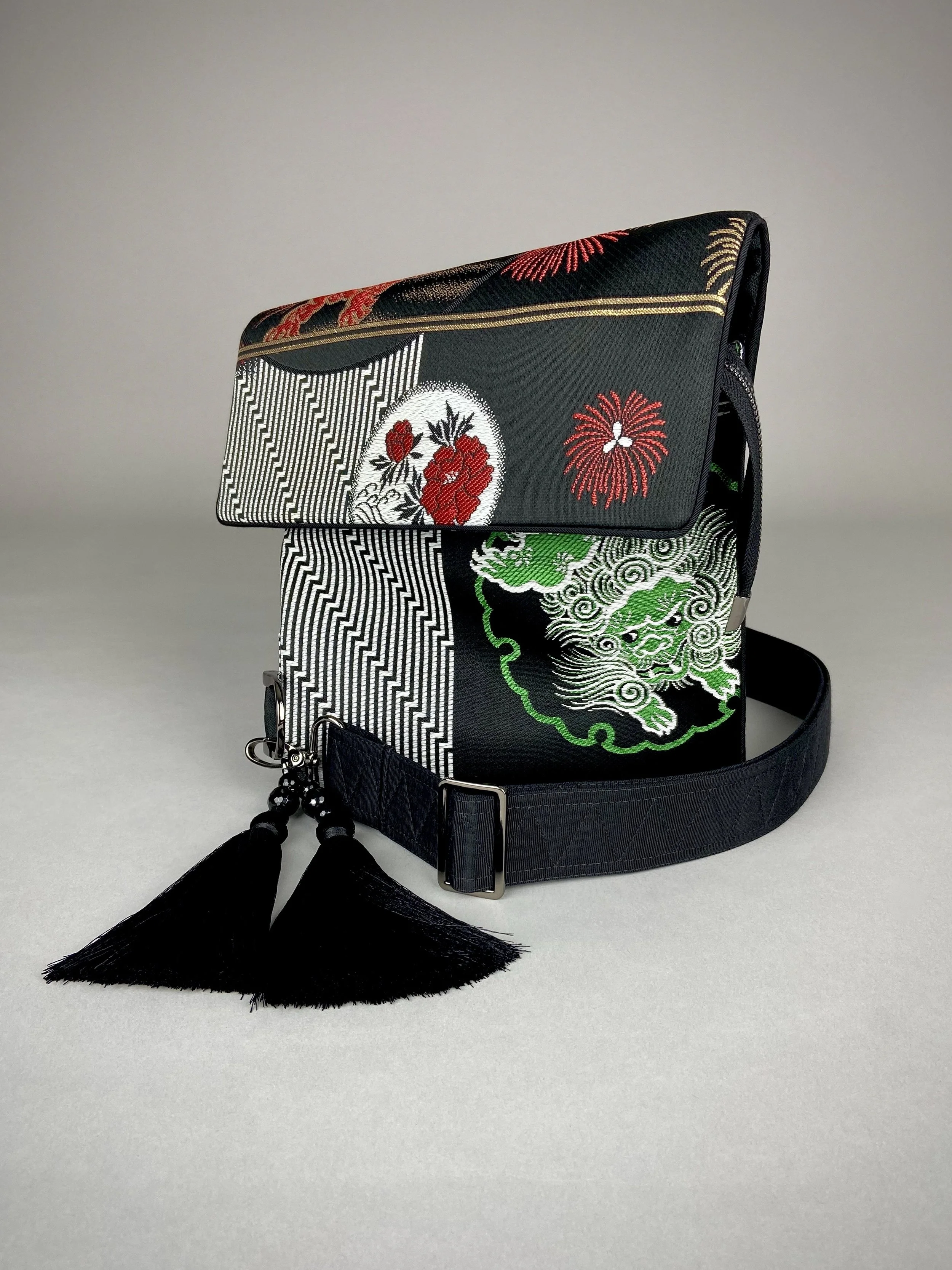 Black matt satin silk and rayon obi bag with red, green, gold and ivory dragon motifs, gunmetal hardware and black tassel charm by Kirsty Chivers