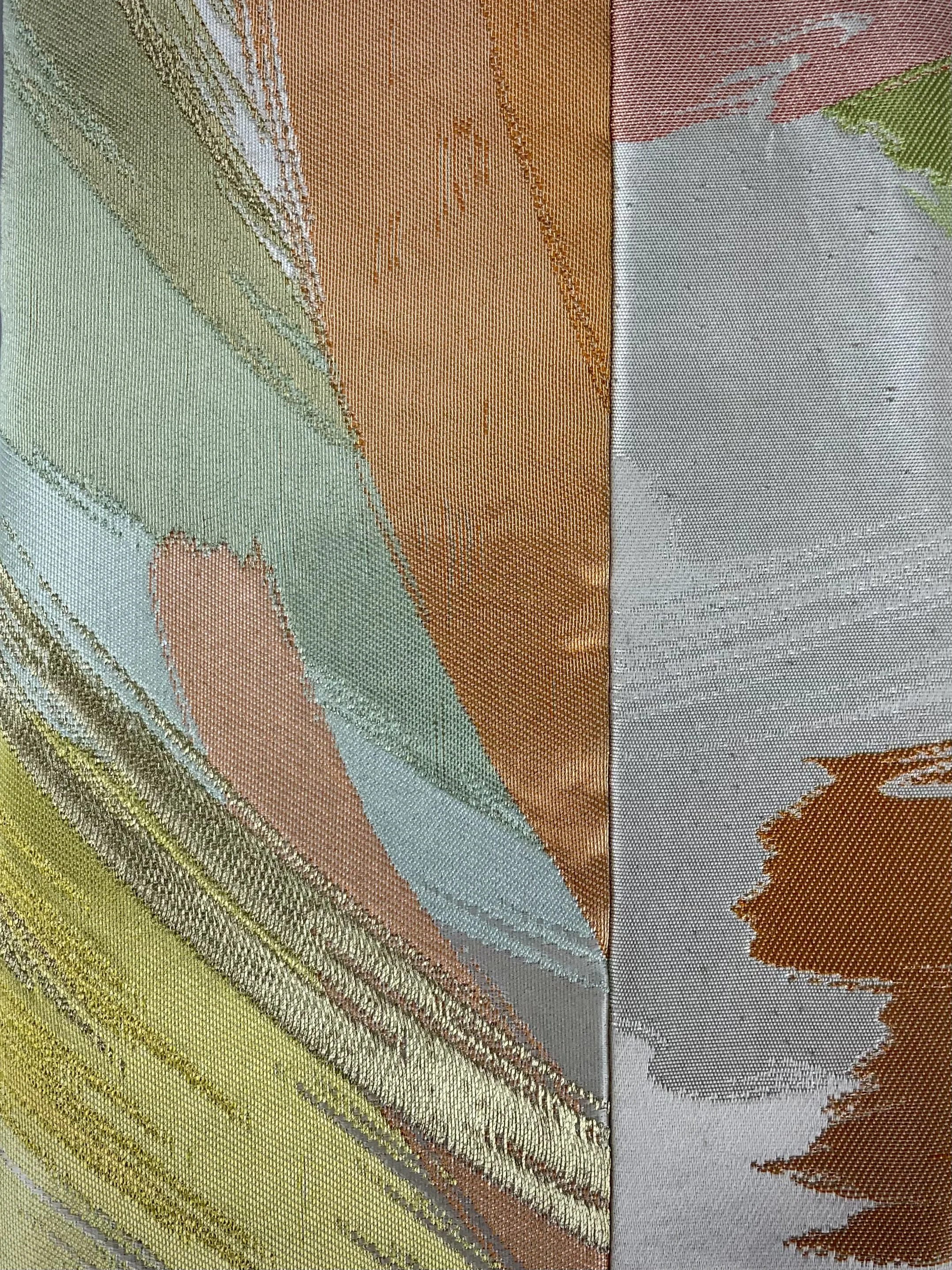 Closeup of wristlet purse made from repurposed vintage obi fabric with brushstroke pastel design and gold silver threads