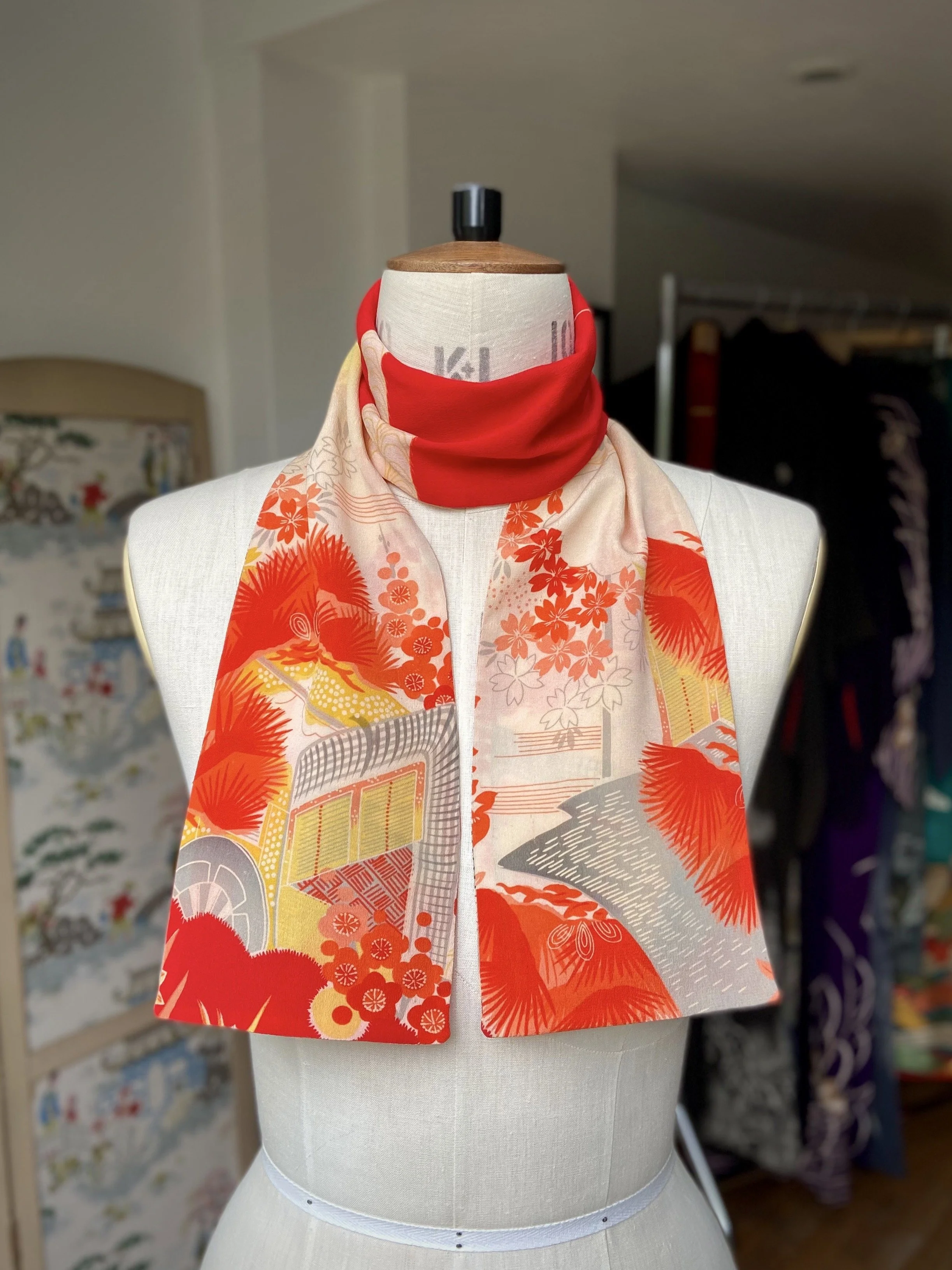 Bright vermillion red and yellow scarf presented on a dress stand, with printed blossom design, handmade from repurposed Japanese kimono crepe silk by Kirsty Chivers