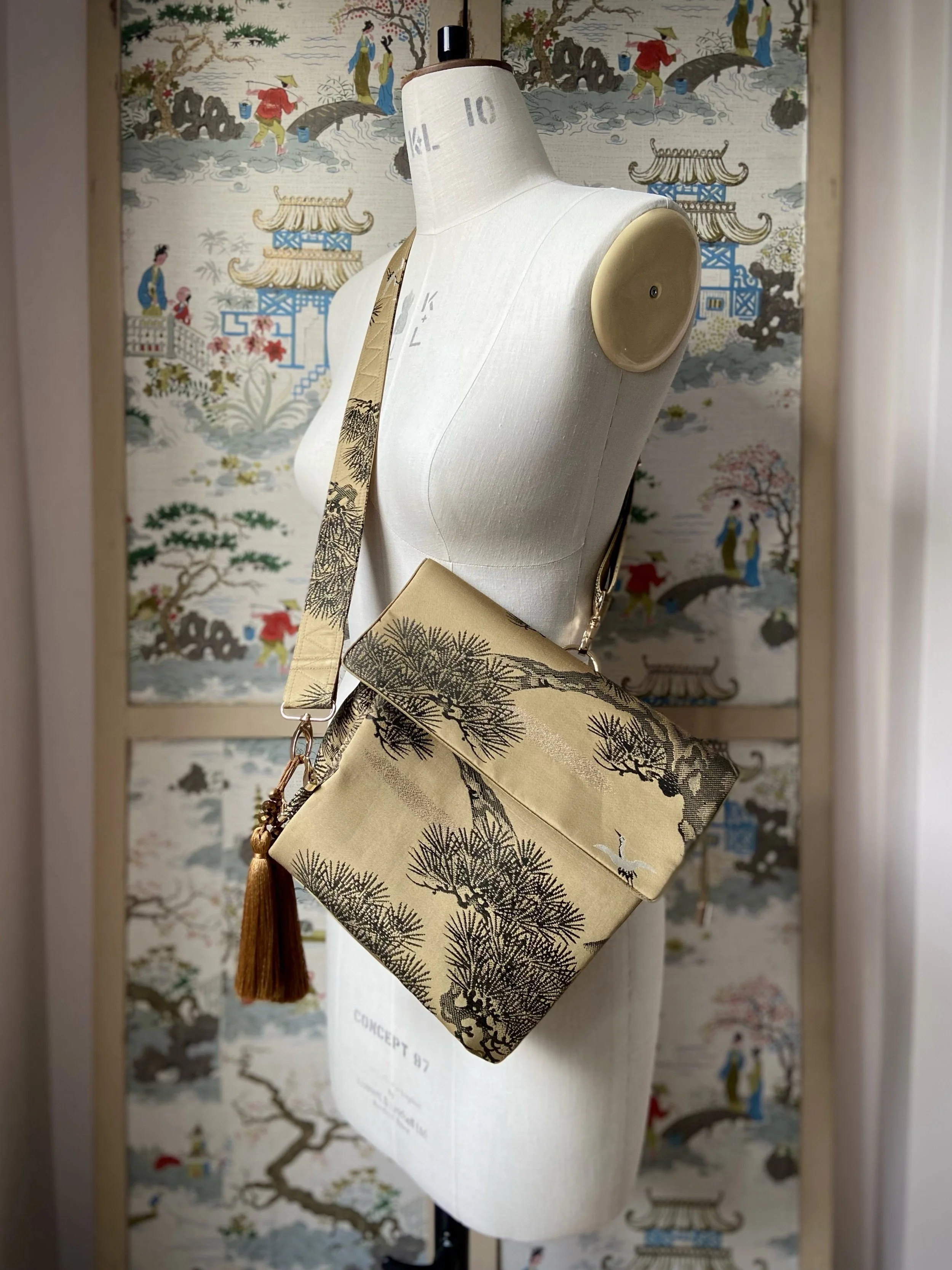 Olive green Matsu pine vintage obi silk shoulder bag with crane design, gold thread detailing and matching fabric tassel charm by Kirsty Chivers