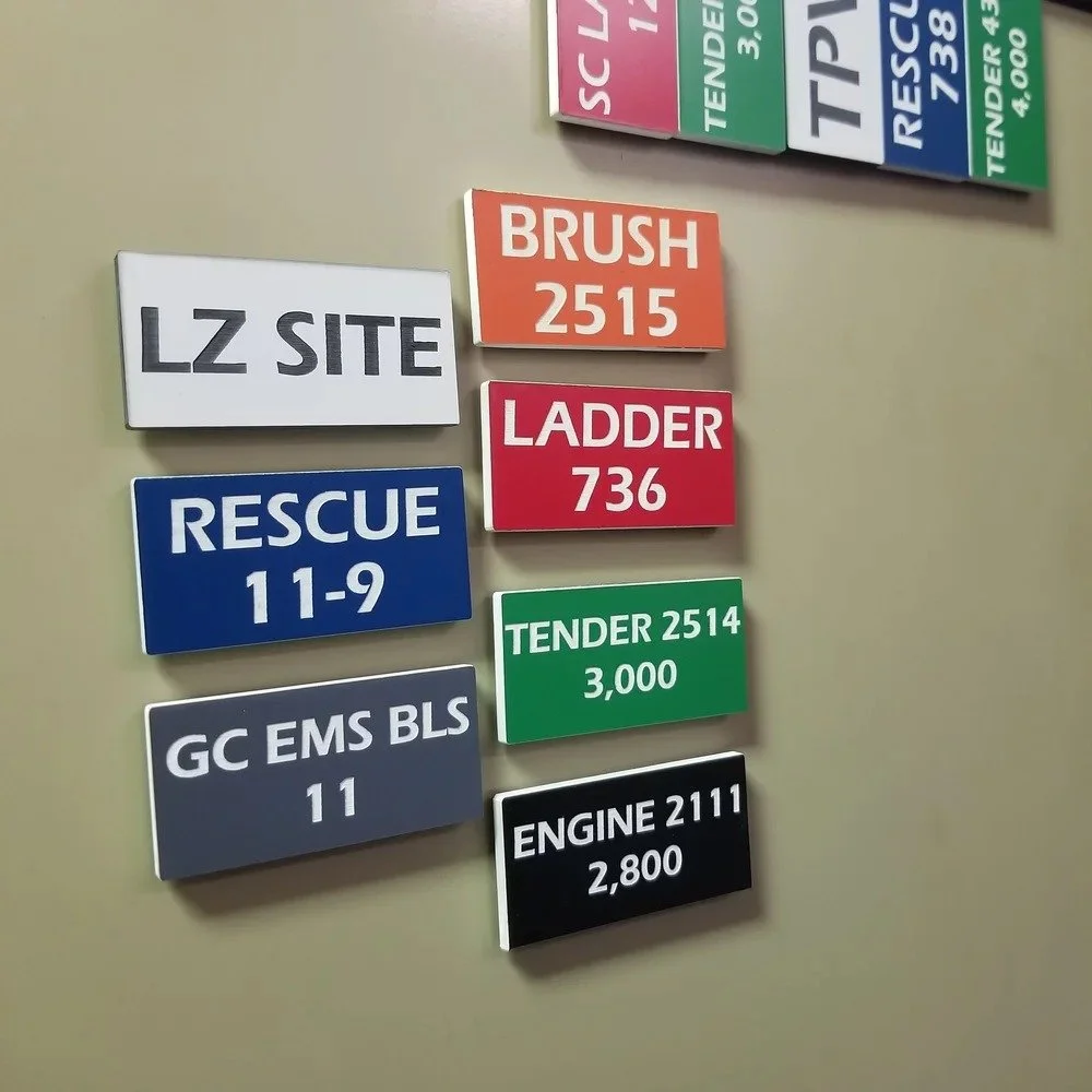 Incident command magnetic tags labeled for fire department units including rescue ladder engine and EMS assignments