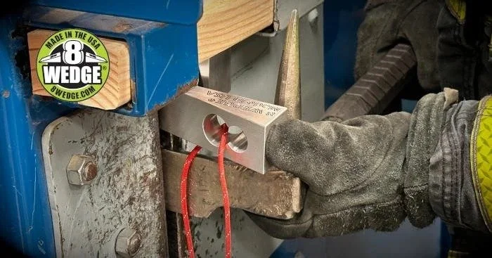 firefighter holding aluminum wedge tool with gloved hand for forcible entry