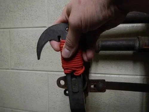 firefighter holding TUF 8 multi tool with lanyard for quick access on gear