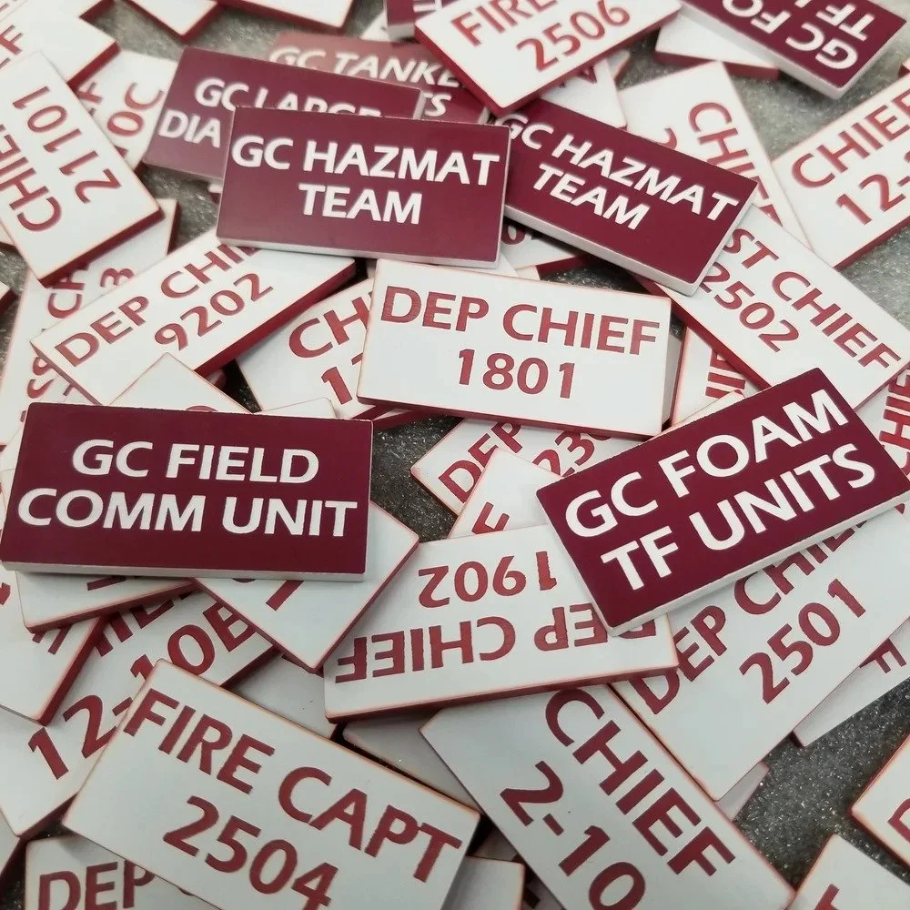 Custom fire department magnetic tags for unit identification showing multiple labeled command board tags