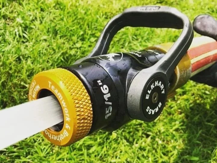Fire hose nozzle with thread protector installed showing real-world use on nozzle threads