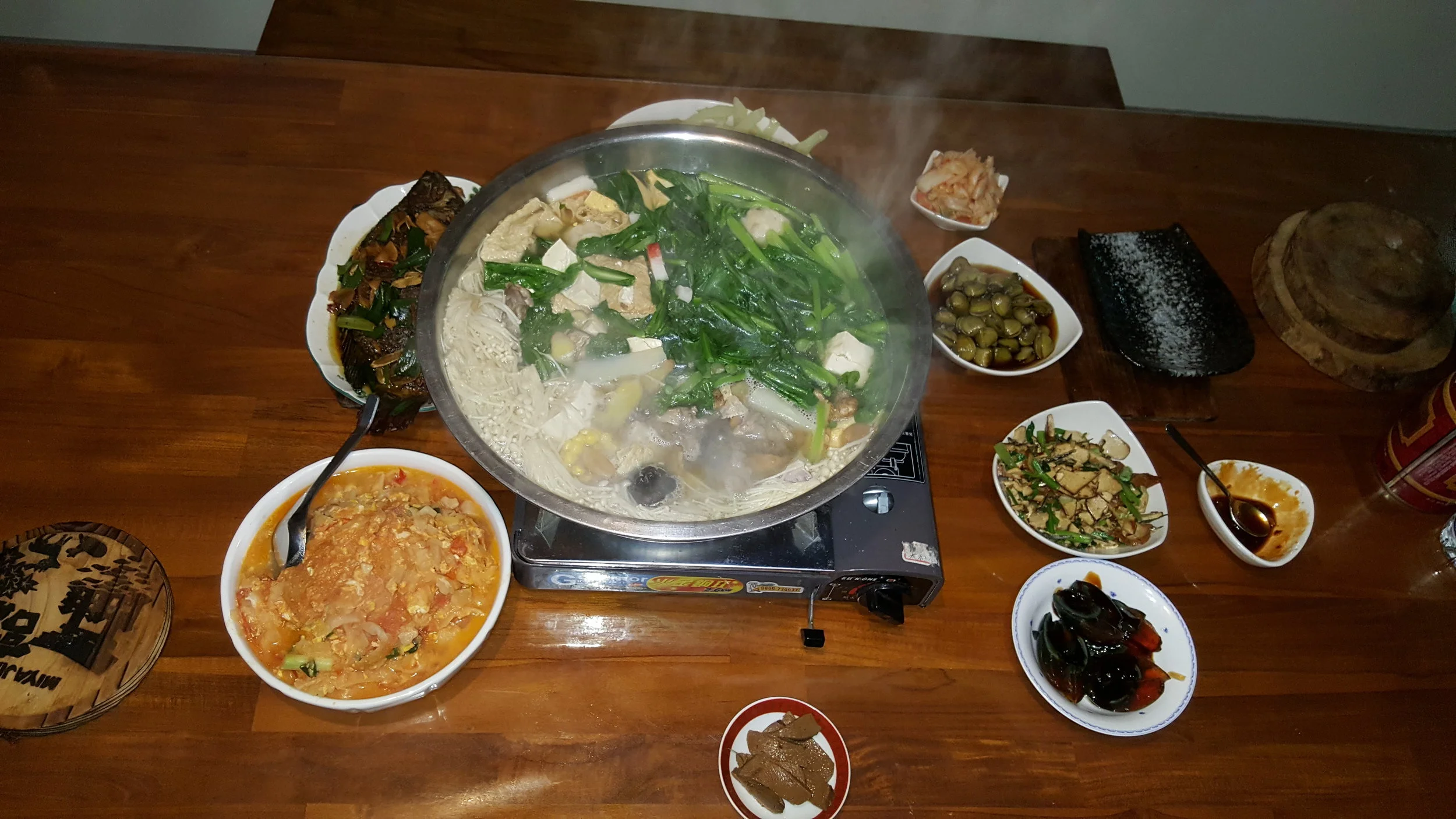 another two courses came out after i took this picture... but here is clams, hot pot, preserved eggs, tomato/bittermelon/egg dish, fried fish, kimchi, pork liver, cauliflower poking out from behind the steaming pot, tofu and chives - plus rice, always.