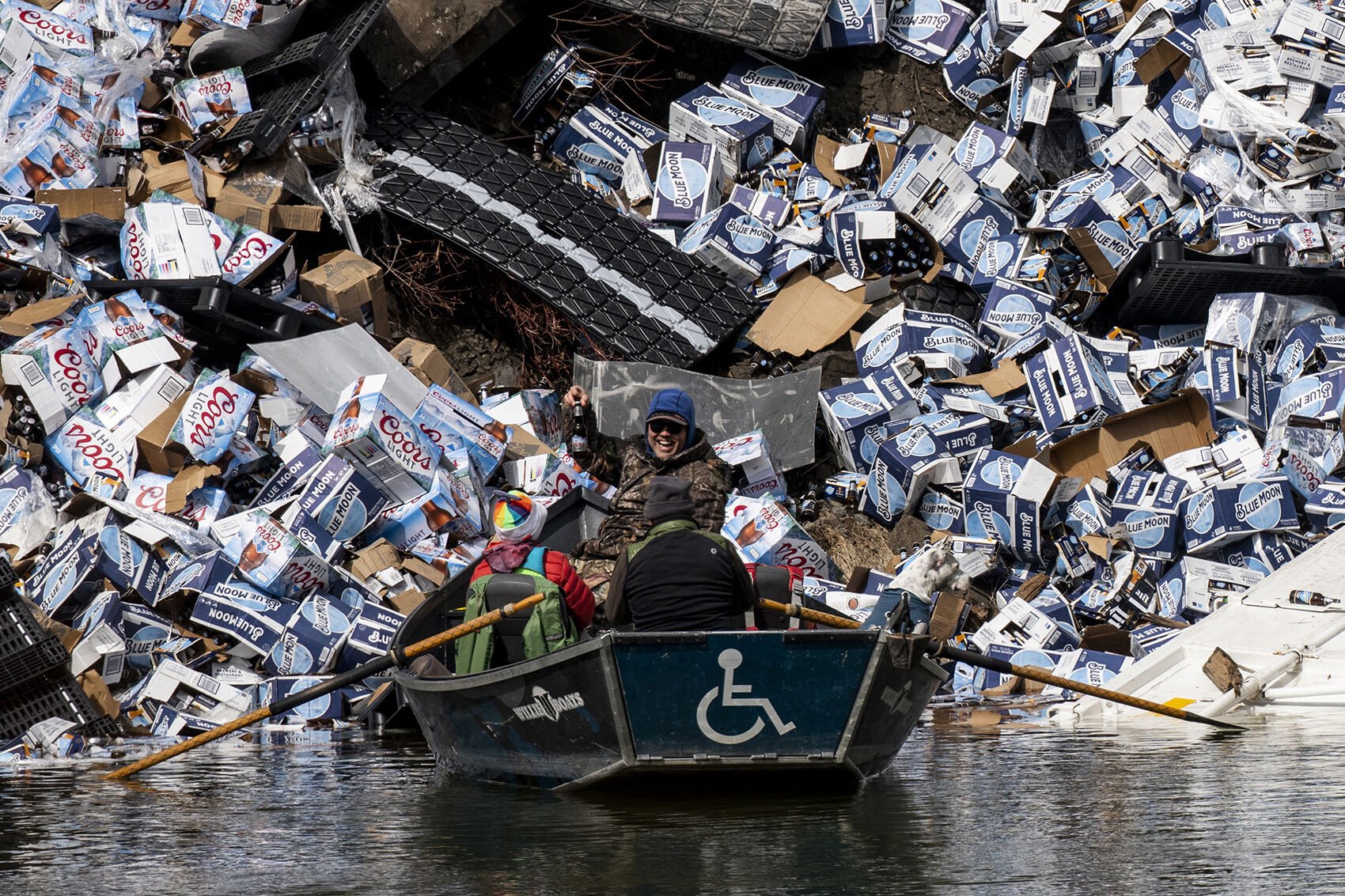  Stephen Smith lifts a bottle of Coors Light from the banks of the Clark Fork River following a train derailment near Quinn's Hot Springs near Plains, Montana, on April 2, 2023. At least 20 cars of a westbound freight train derailed, some containing 