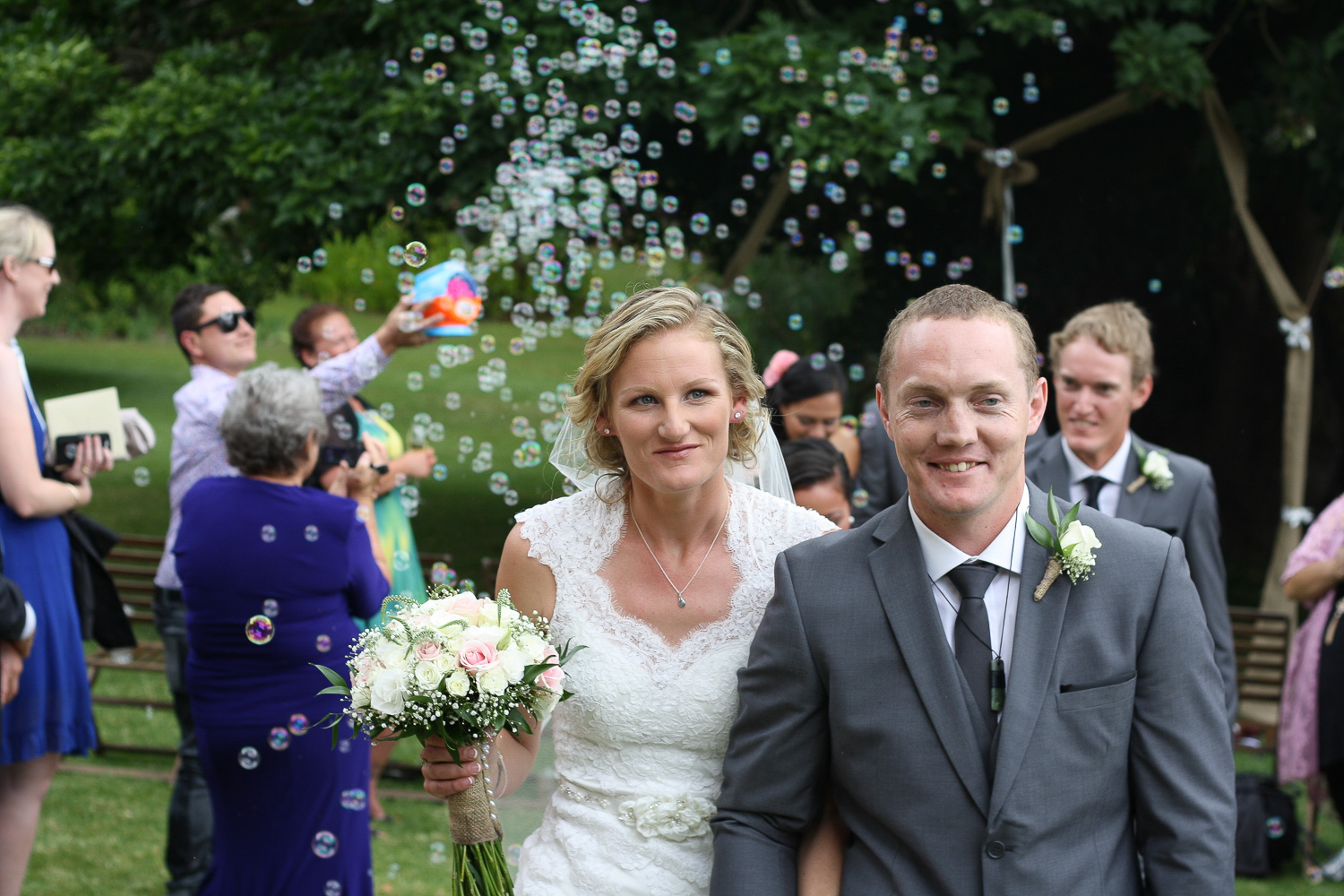 bride_and_groom_just_married_walking_back_through_guests_smiling_and_happy_bubbling_all_around_them.jpg