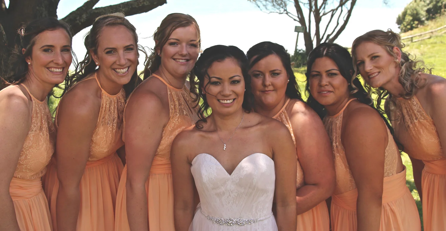 bride_and_her_bridesmaids_in_peach_girl_squad_smiling.jpg