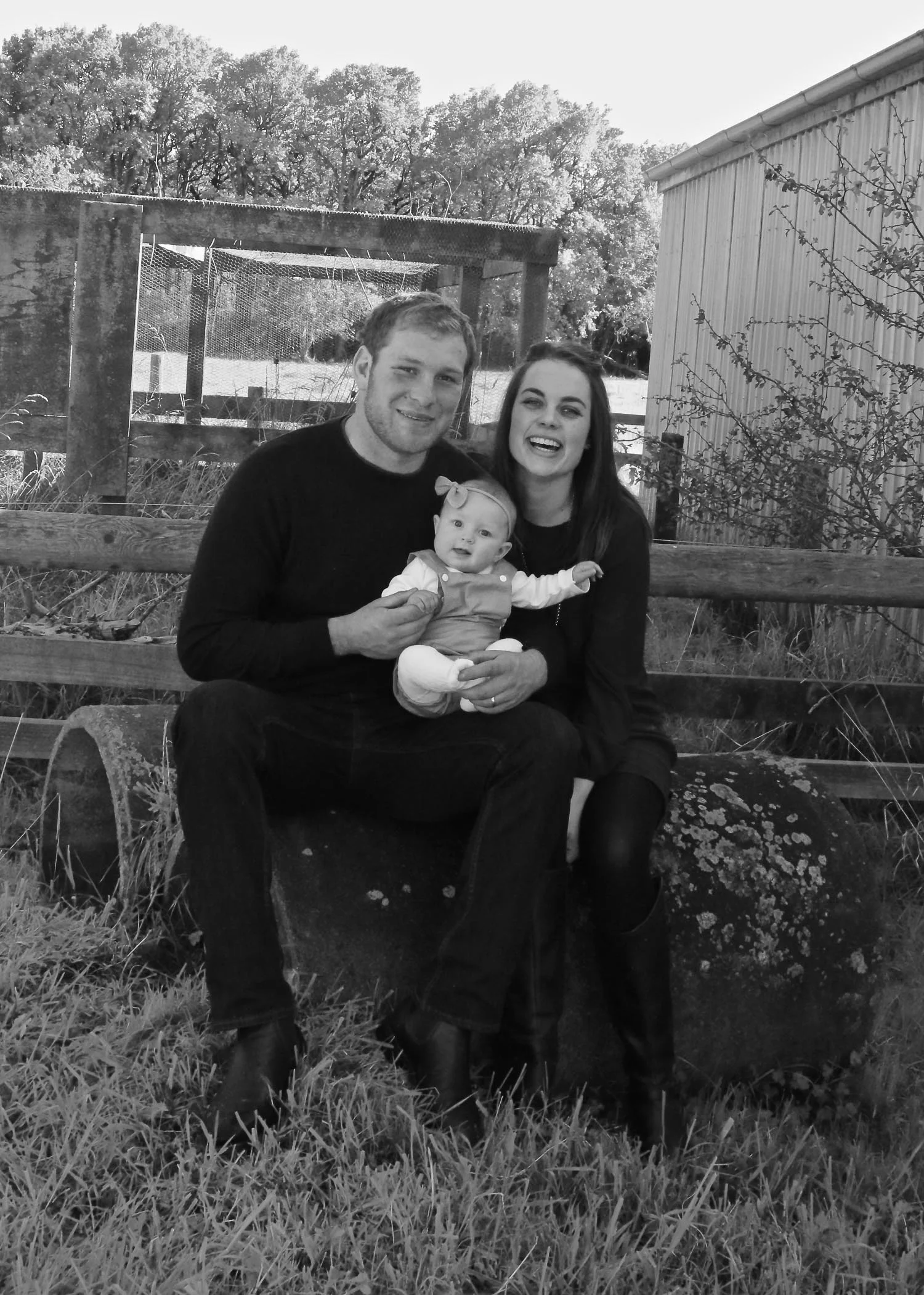 smiling-at-camera-black-and-white-sitting-infront-of-chicken-coop.jpg