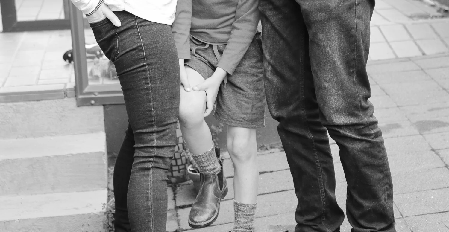 boy-hurt-himself-being-comforted-by-mum-and-dad-black-and-white.jpg