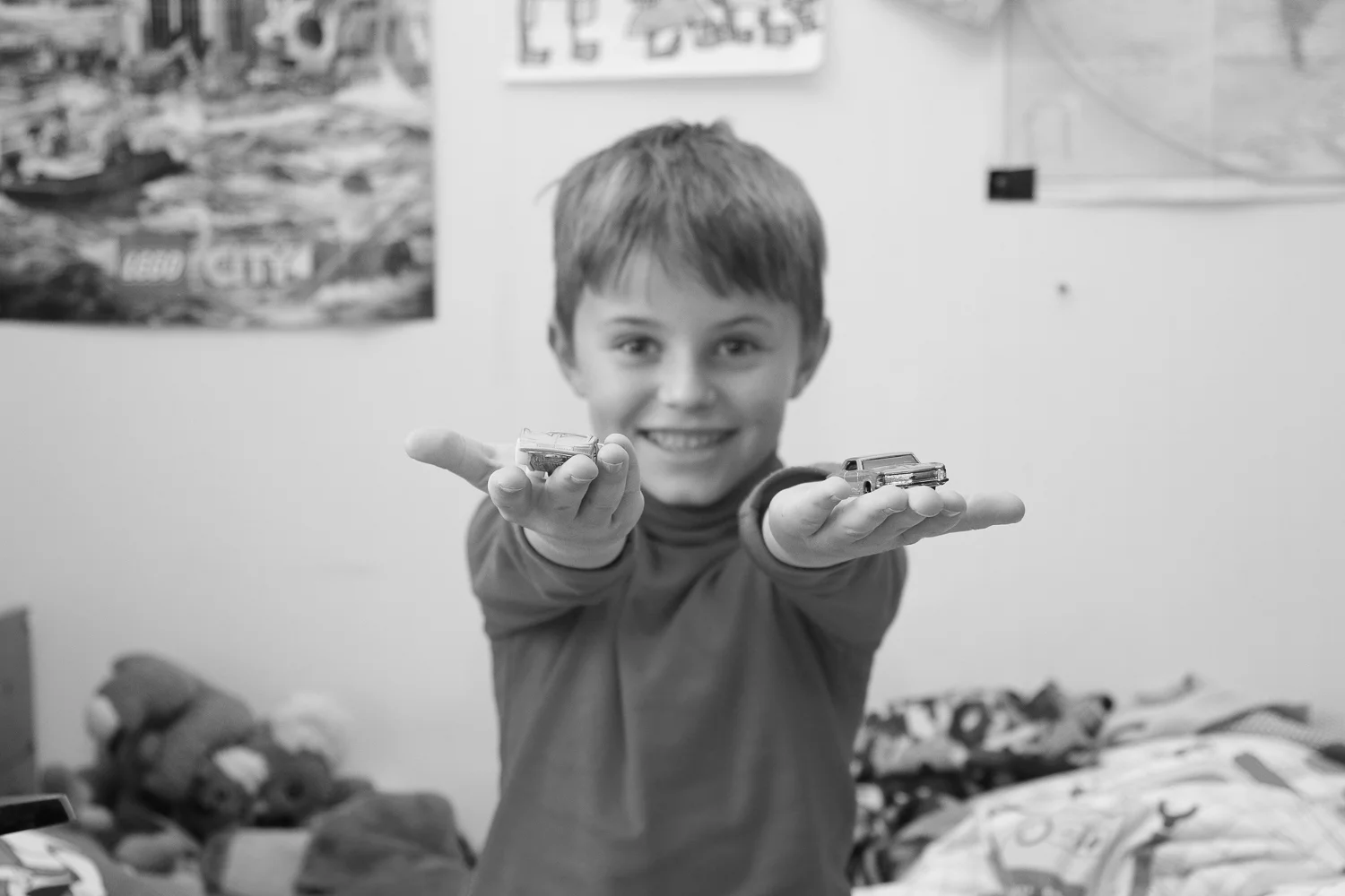 boy-showing-off-his-favourite-toy-cars-black-and-white.jpg