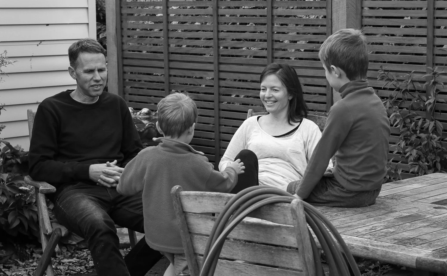 mother-and-father-and-two-boys-sitting-together-laughing-spring-afternoon-happy-together-black-and-white.jpg