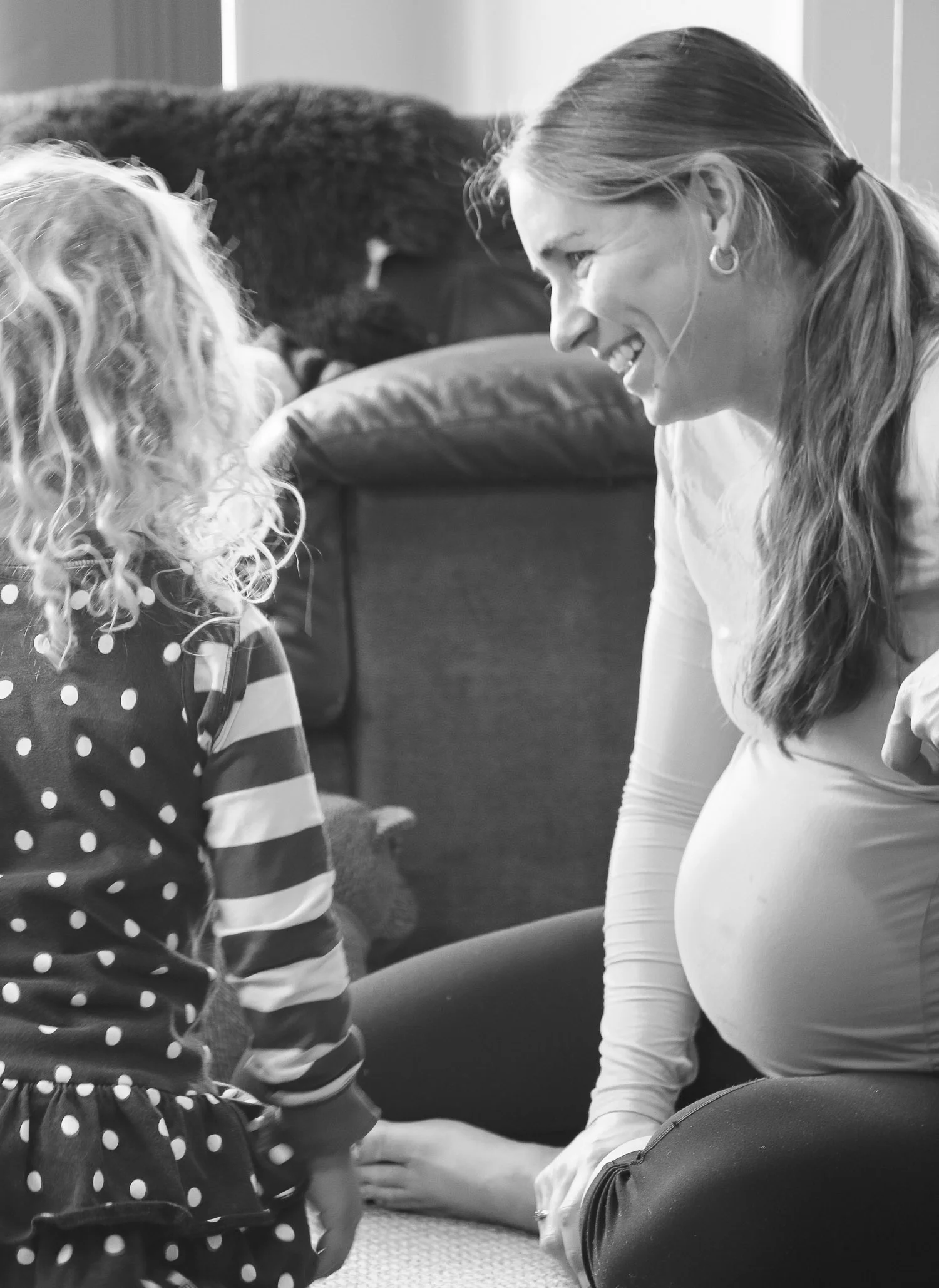 pregnant-mum-sitting-with-daughters-lauhging.jpg