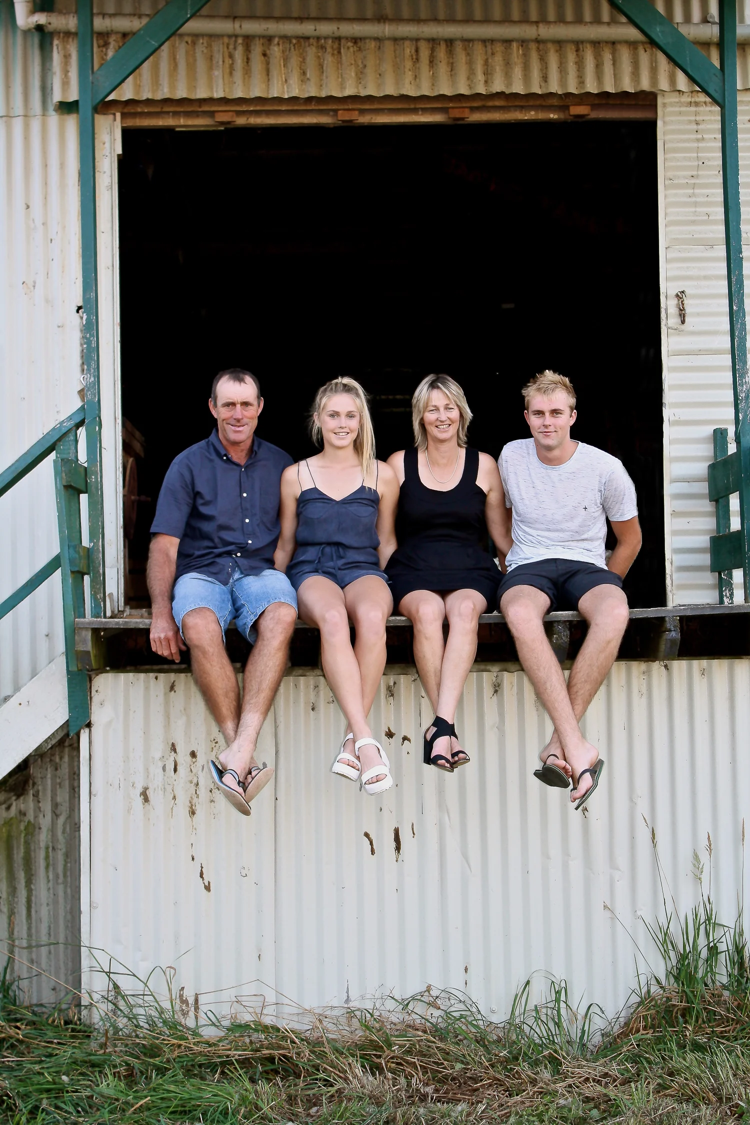 farming family sitting on woolshed steps