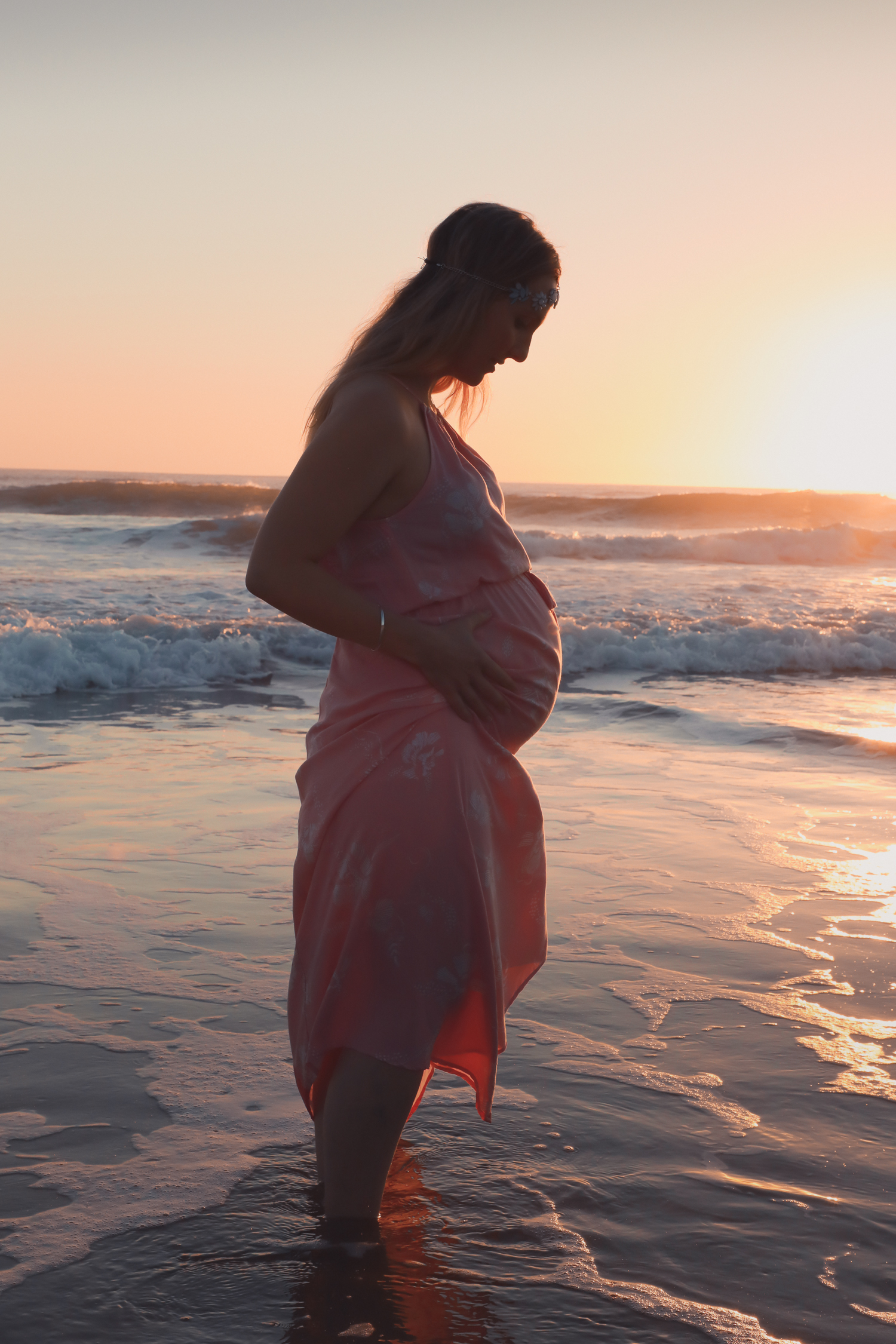 pregnant woman in ocean at sunrise