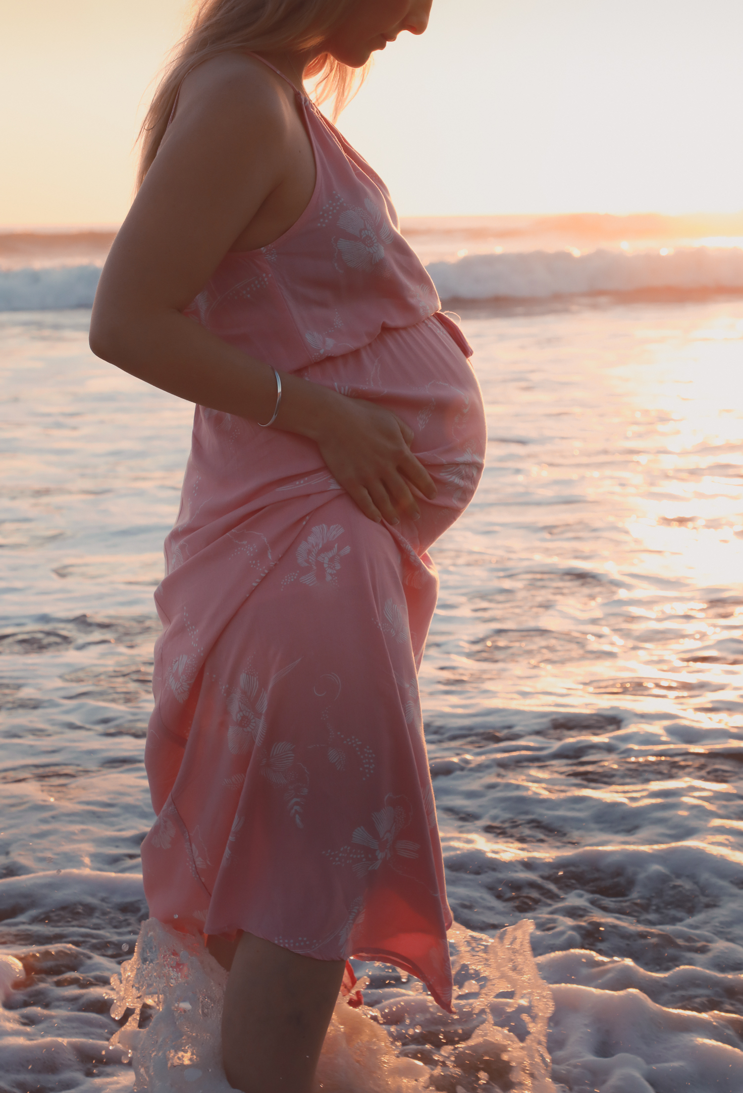 pregnant woman in ocean at sunrise